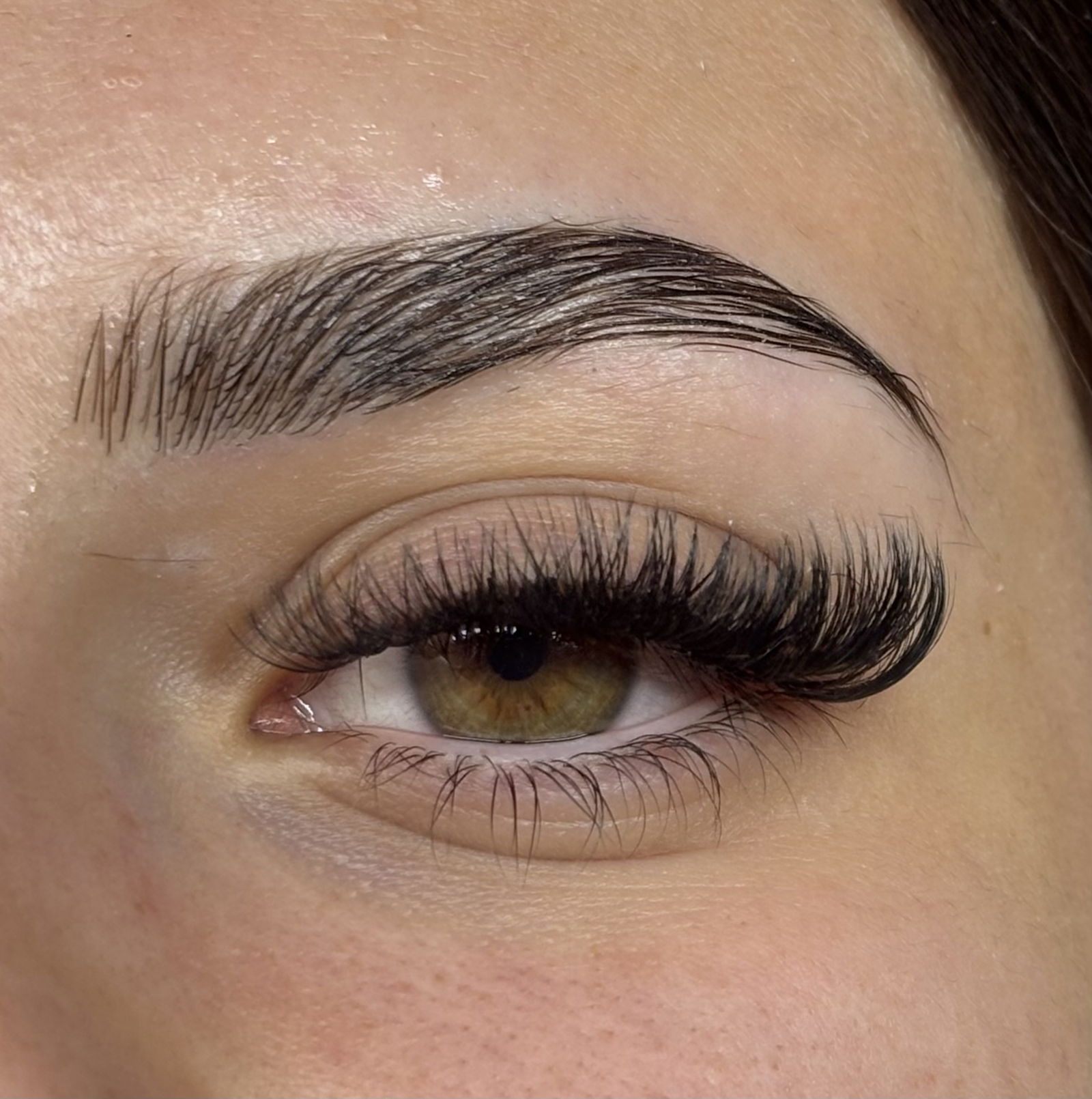 Browlift et extensions de cils volume sur œil noisette – regard intense et sourcils disciplinés pour une mise en beauté complète.