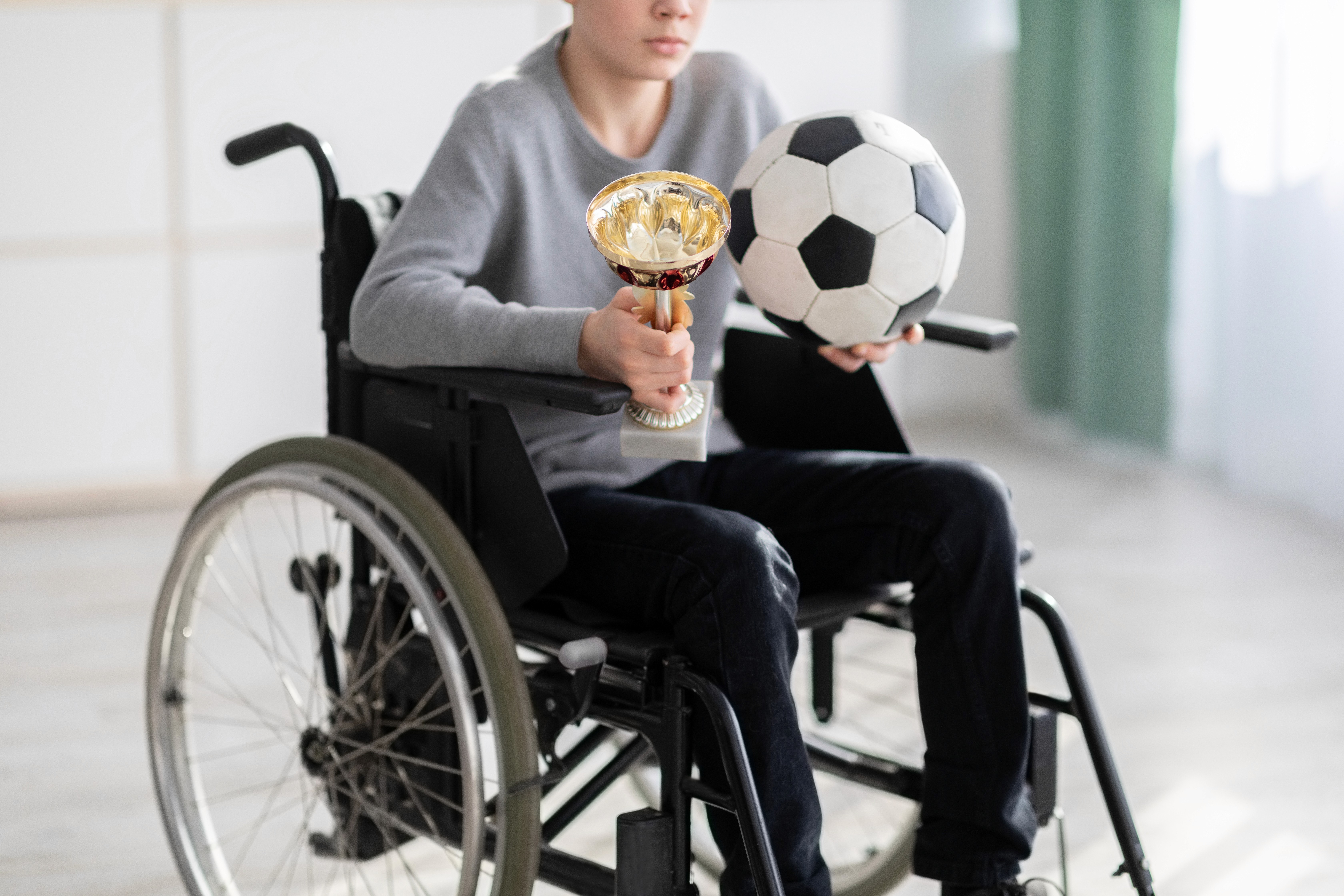 Group of people standing around a white desk during a casual meeting with laptops and coffee cups.