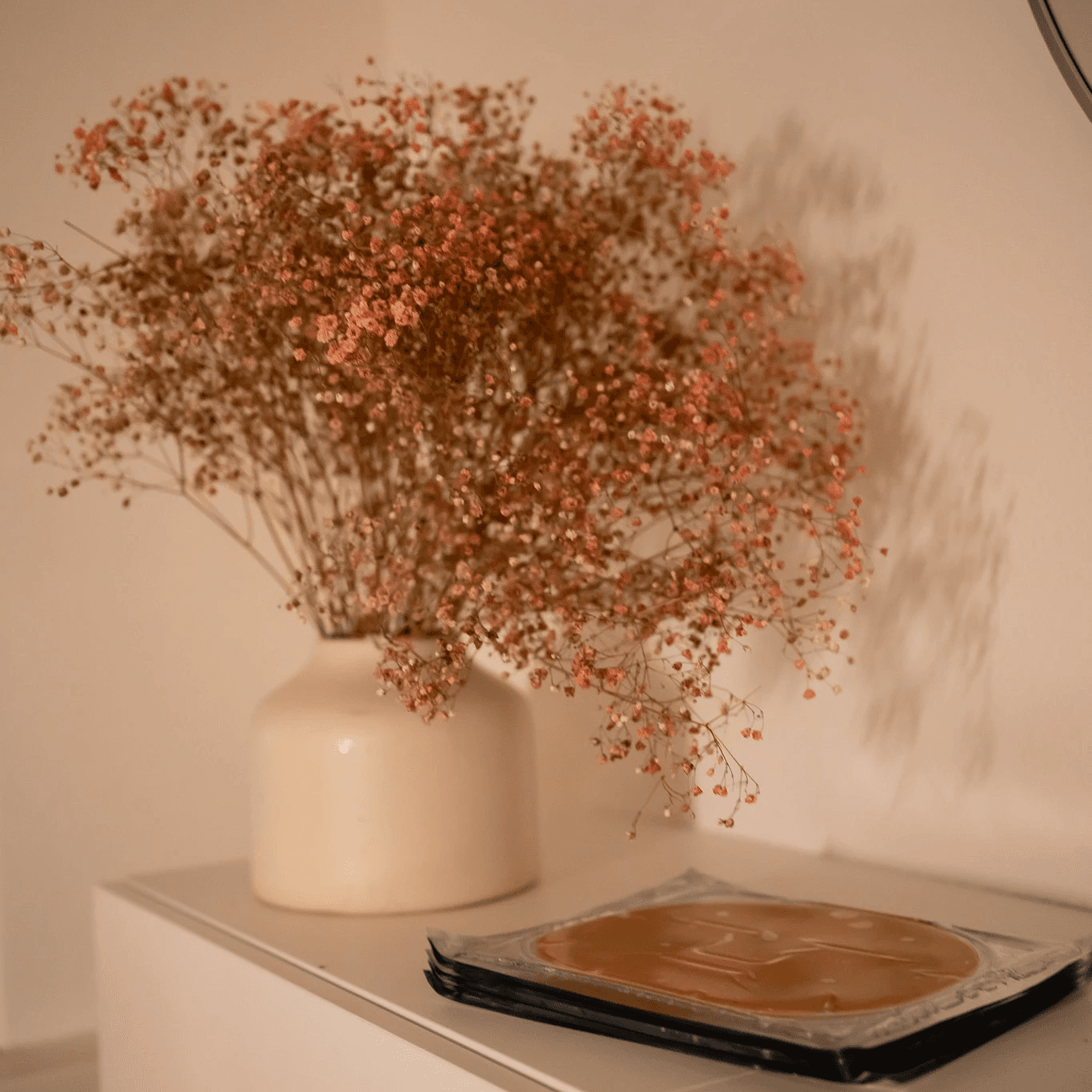 Smiling woman holding documents and using her phone in an office