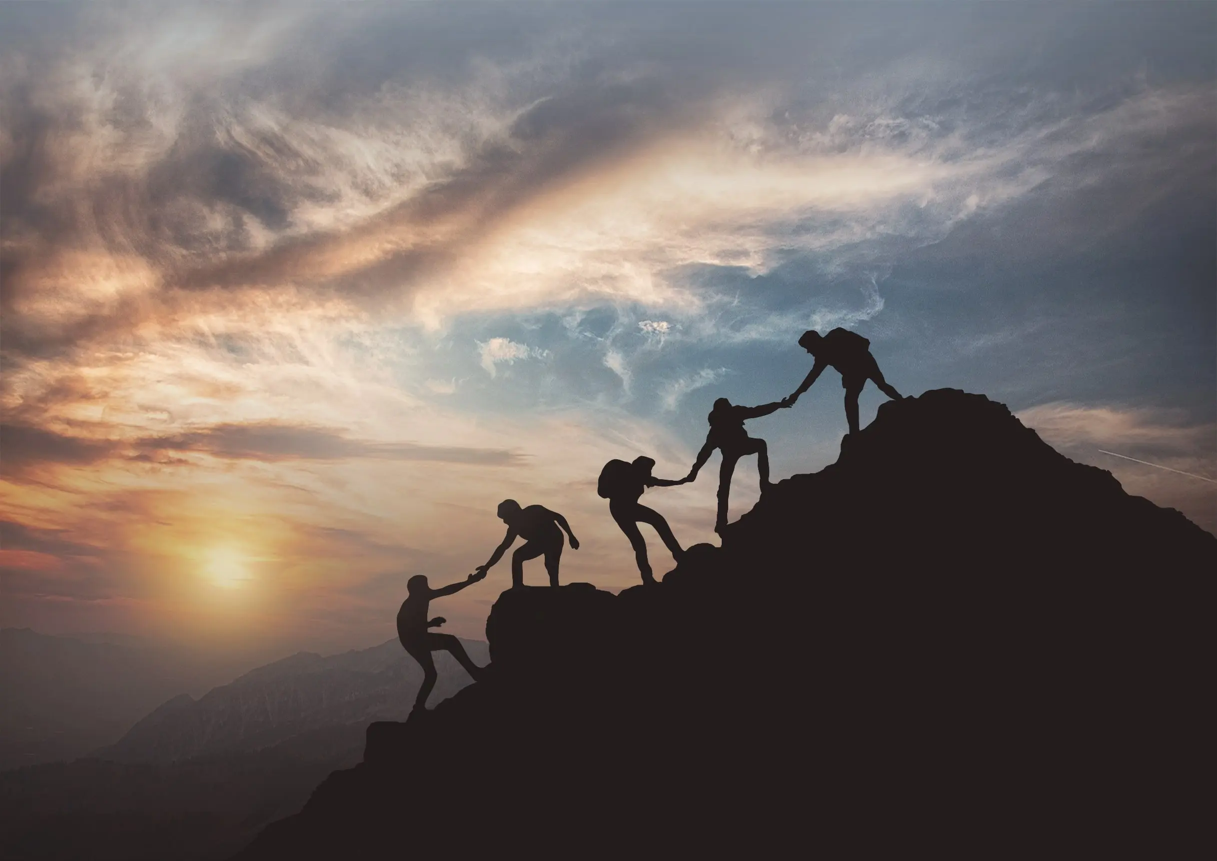 5 climbers in a row helping each other up a mountain at dusk 