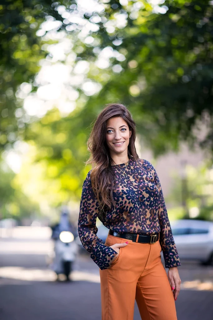 woman in orange trousers posting on on the streets of Amsterdam