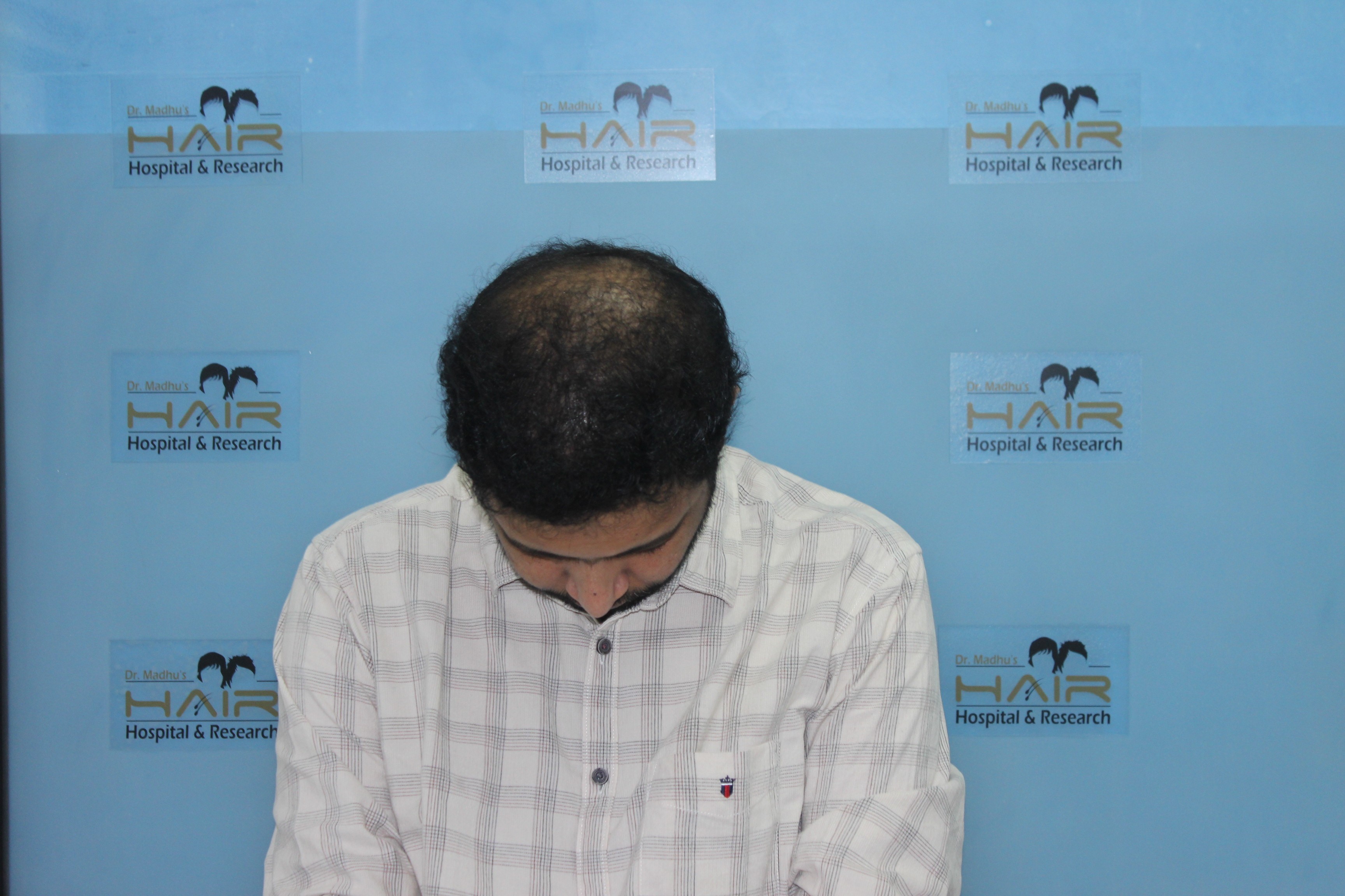 Smiling person with curly hair and closed eyes against clear sky