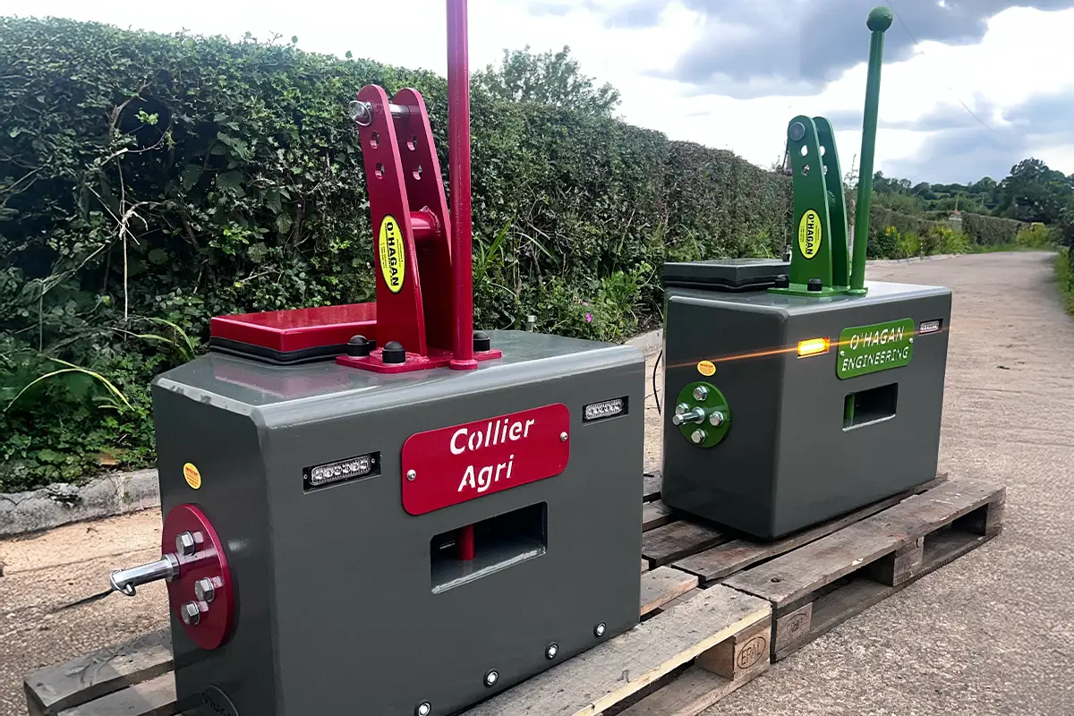 grey and red weight block on a pallet with a customised name plate beside a grey and green weight block on a pallet on a lane