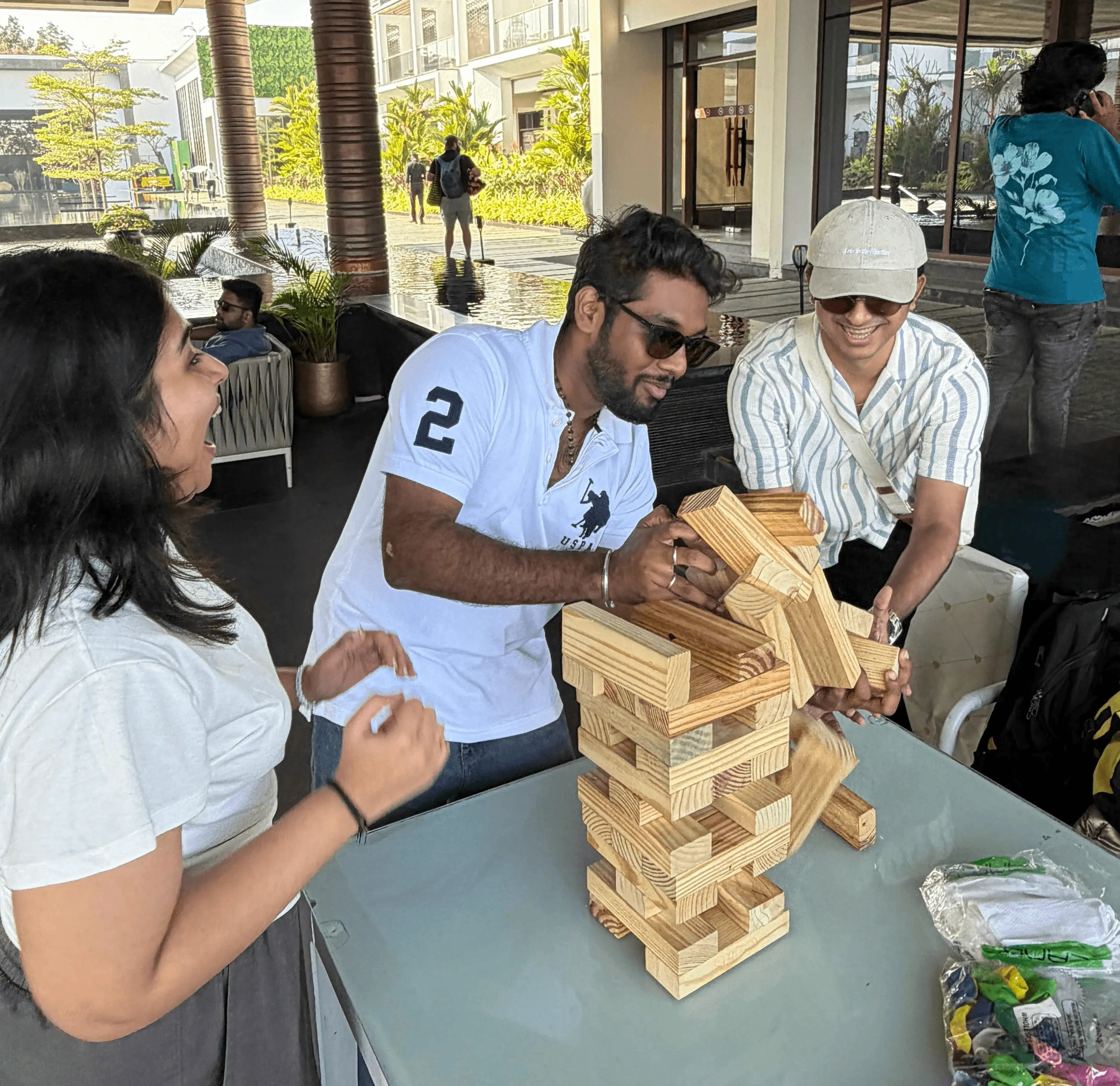 Team members playing a wooden block stacking game together during a collaborative team-building activity.