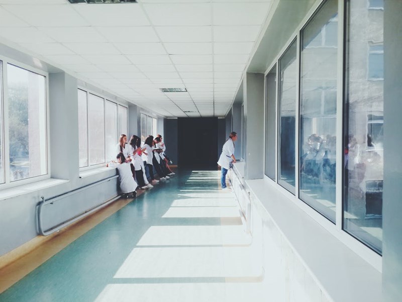 Medical staff in white coats gathered in a bright hospital corridor