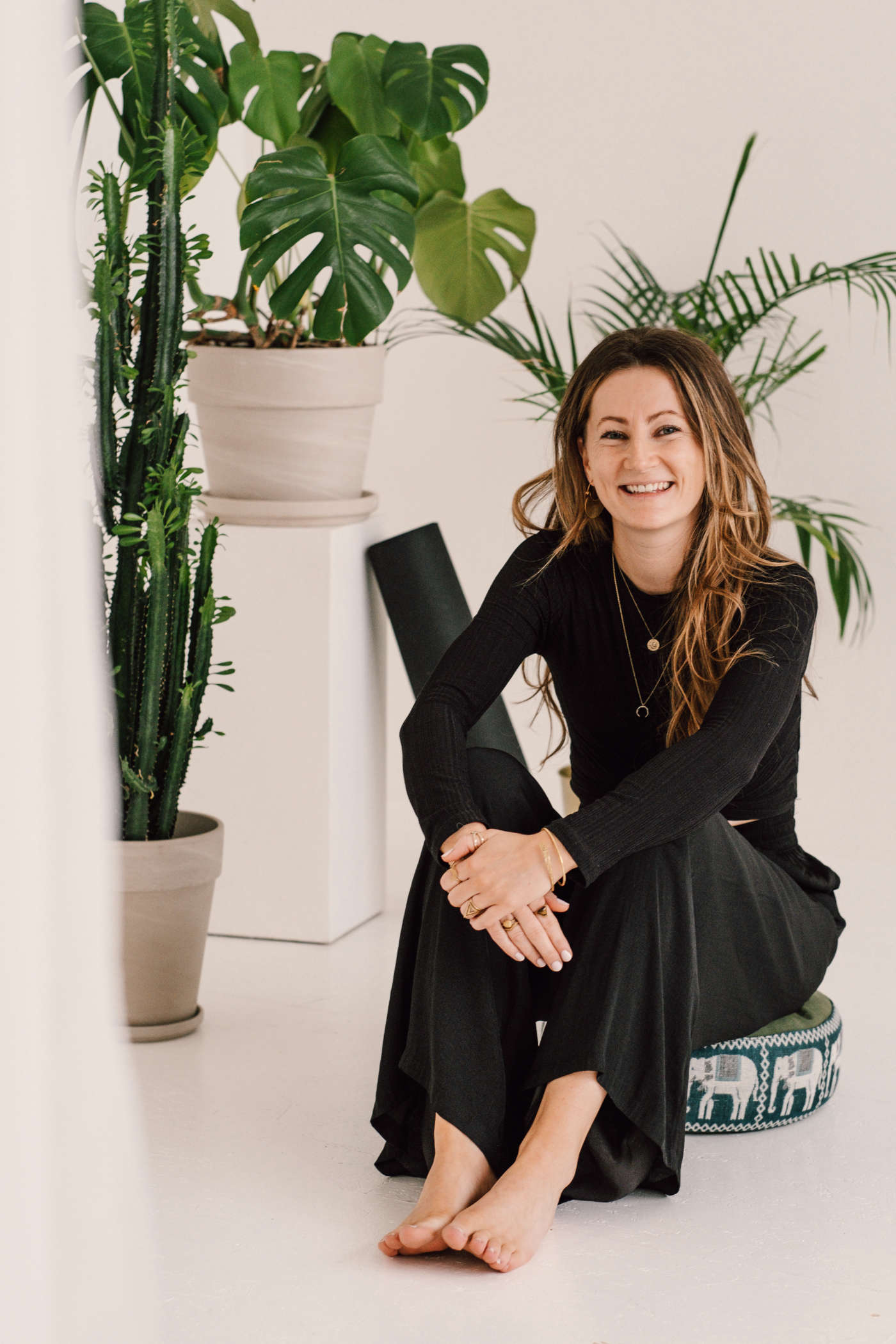 Franzi sitzt lächelnd auf Yogamatte