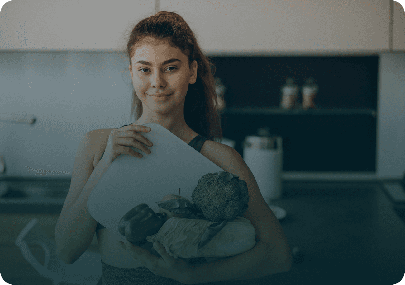 Young sporty woman with scales and vegetables at the kitchen