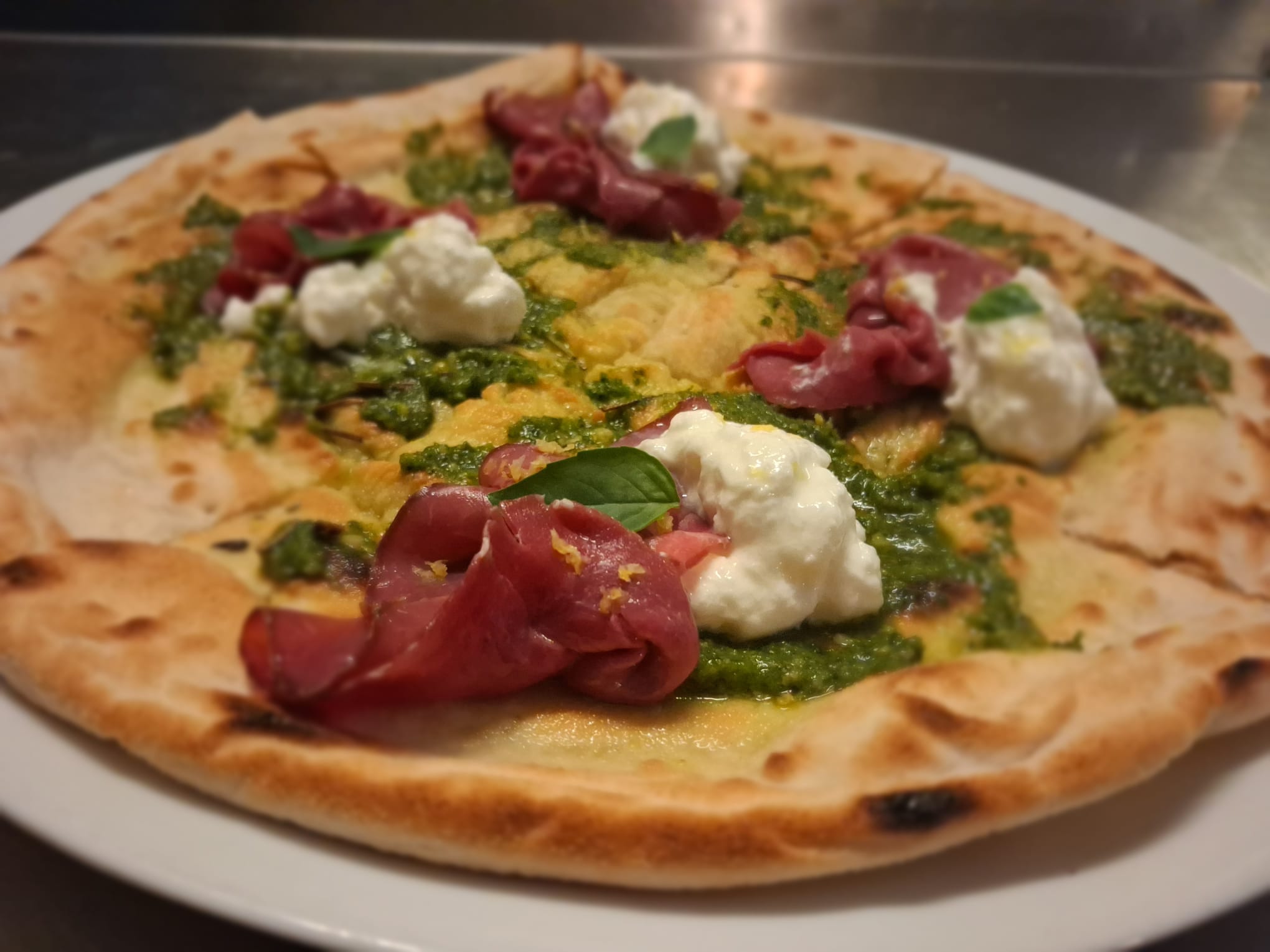 Pizza appena sfornata su tavolo in legno