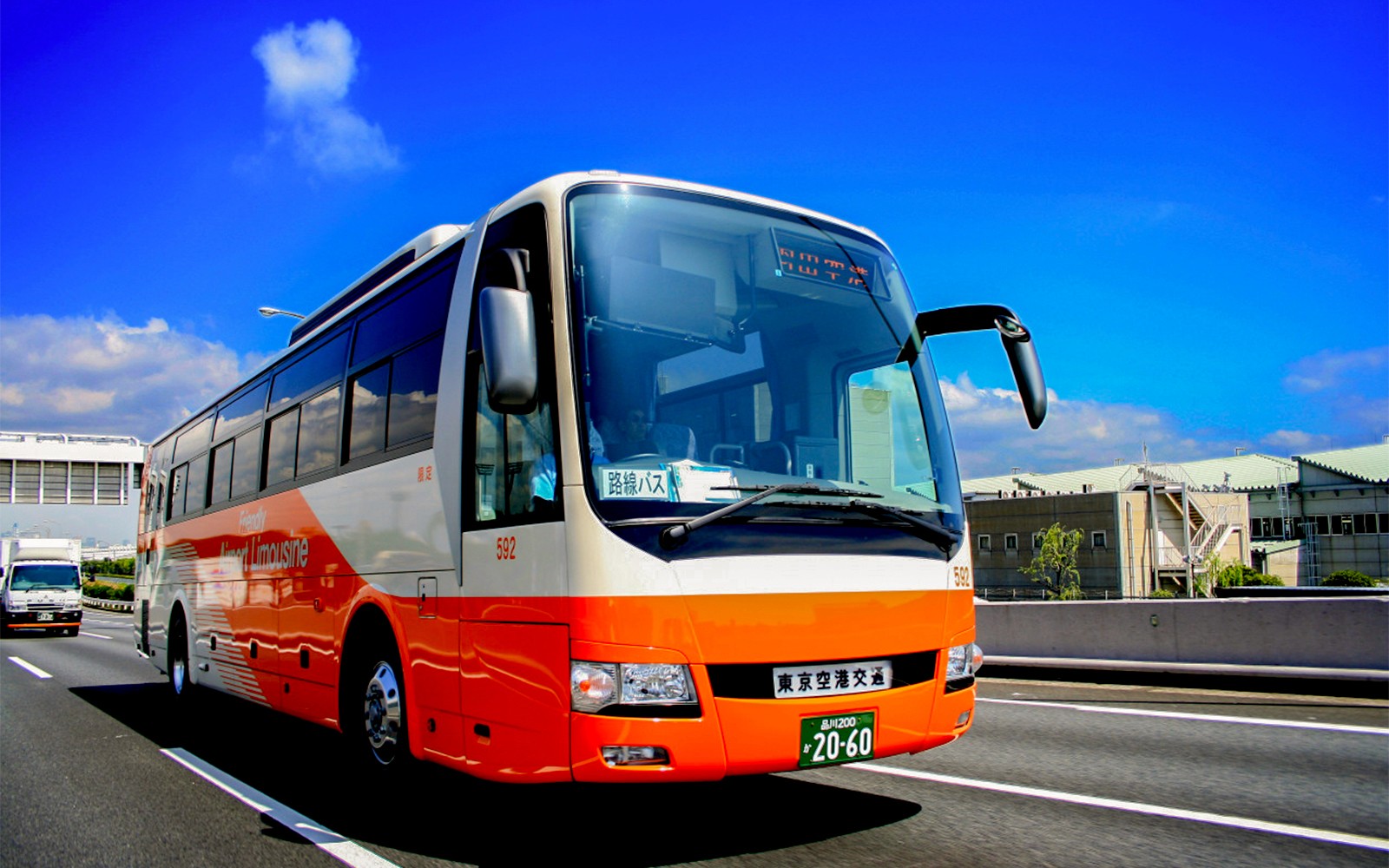 豪華巴士駛過東京中環，載送遊客從羽田機場出發。