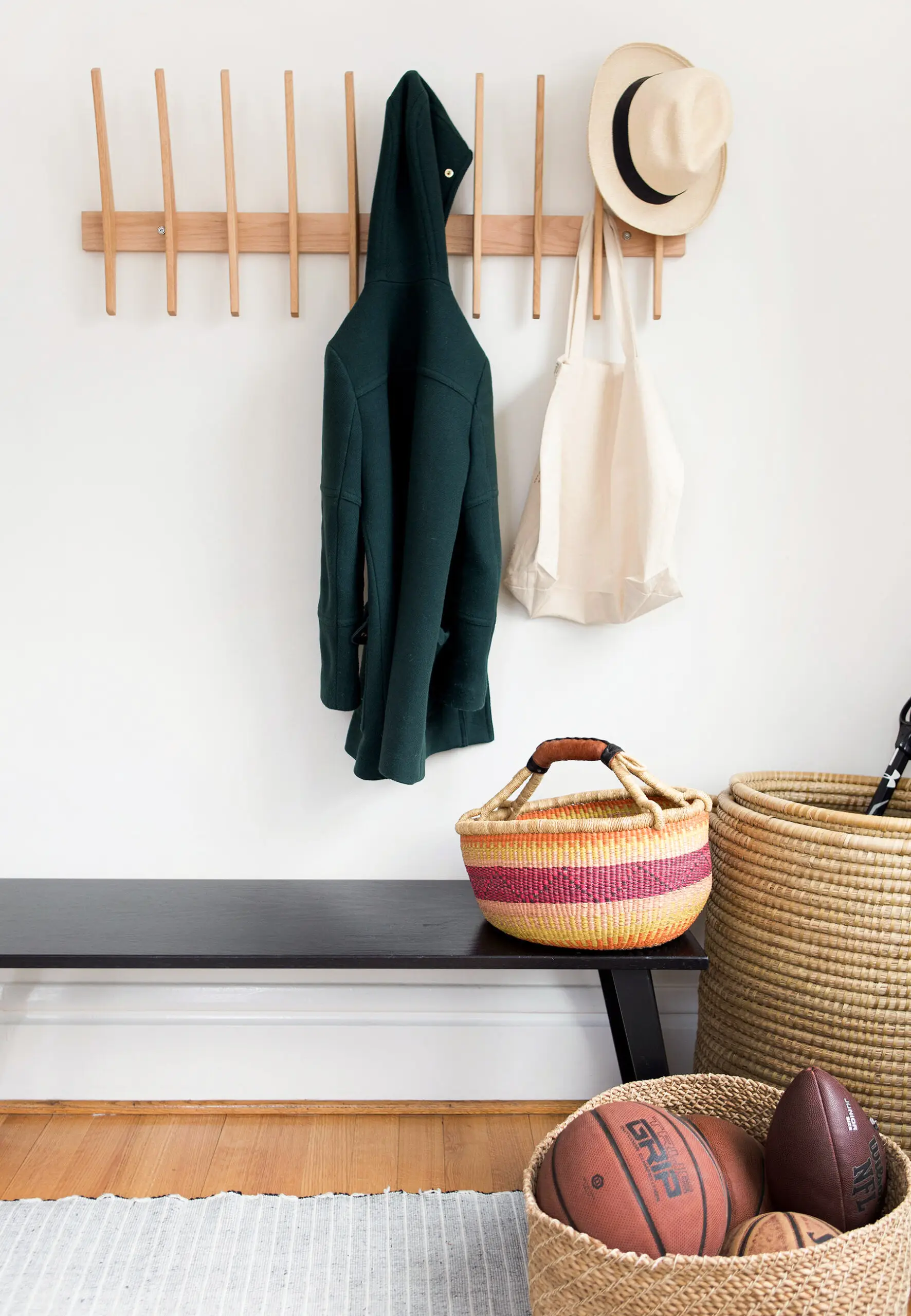Coat, hat, and tote bag on rack over bench
