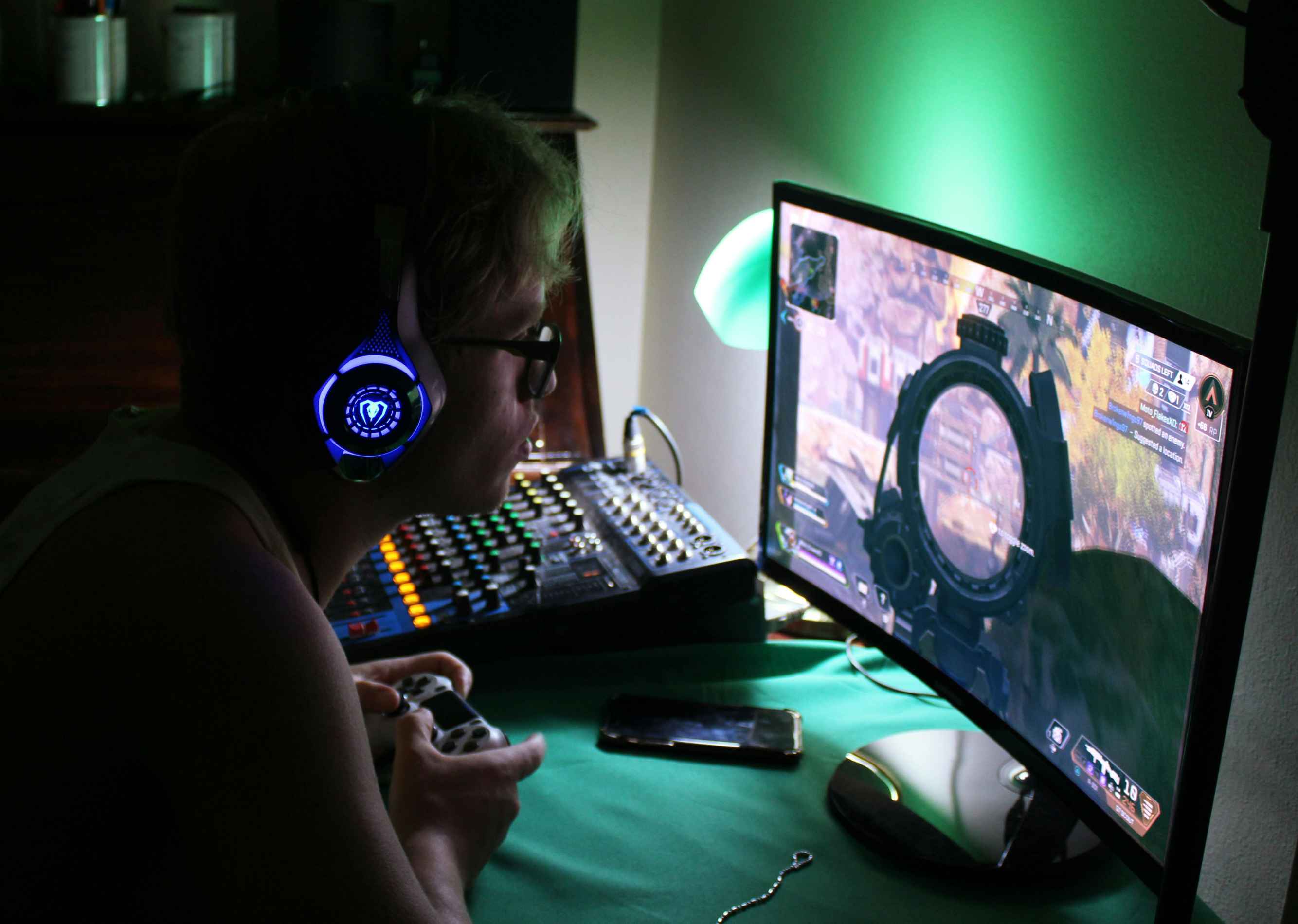 Gamer live-streaming esports gameplay with headphones and a console setup