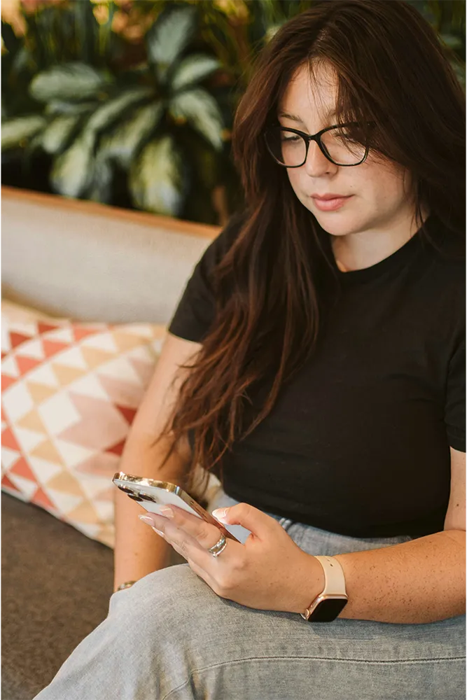 Woman sitting on the couch looking at her phone