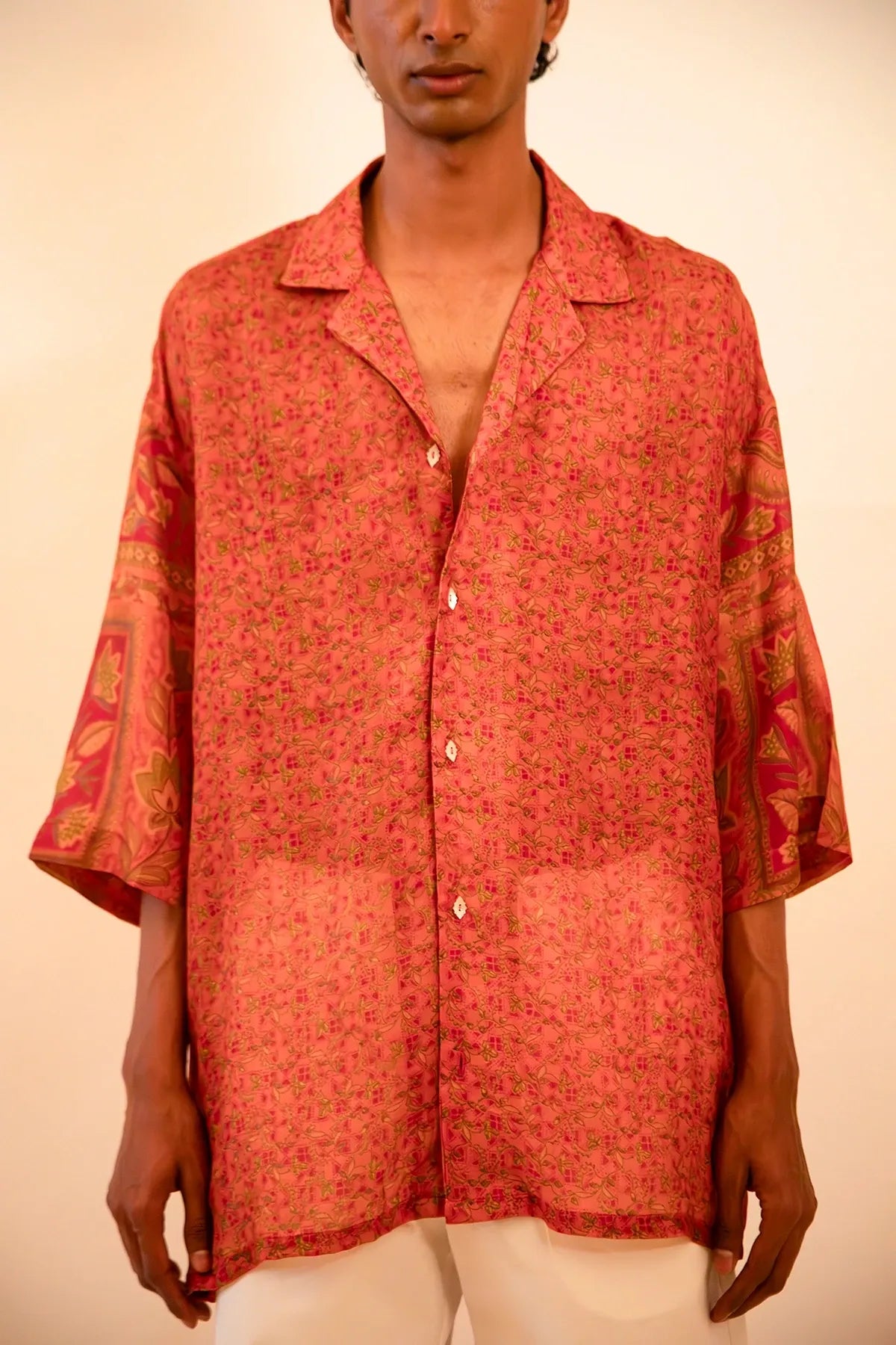 Oversized orange printed silk shirt handcrafted from a vintage sari, featuring a relaxed fit, 3/4 sleeves, soft texture, and playful button details, celebrating comfort, craft, and thoughtful design.