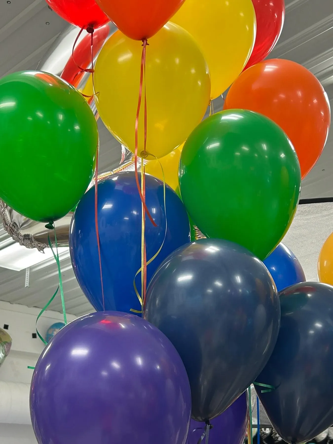 Cluster of large rainbow-colored balloons including red, orange, yellow, green, blue, and purple balloons prepared by Be Bold Balloons