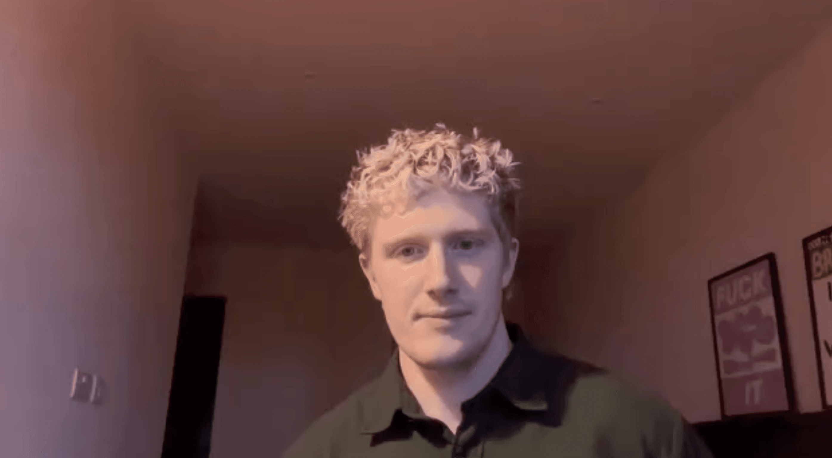 Profile portrait of a man in a white shirt against a light background