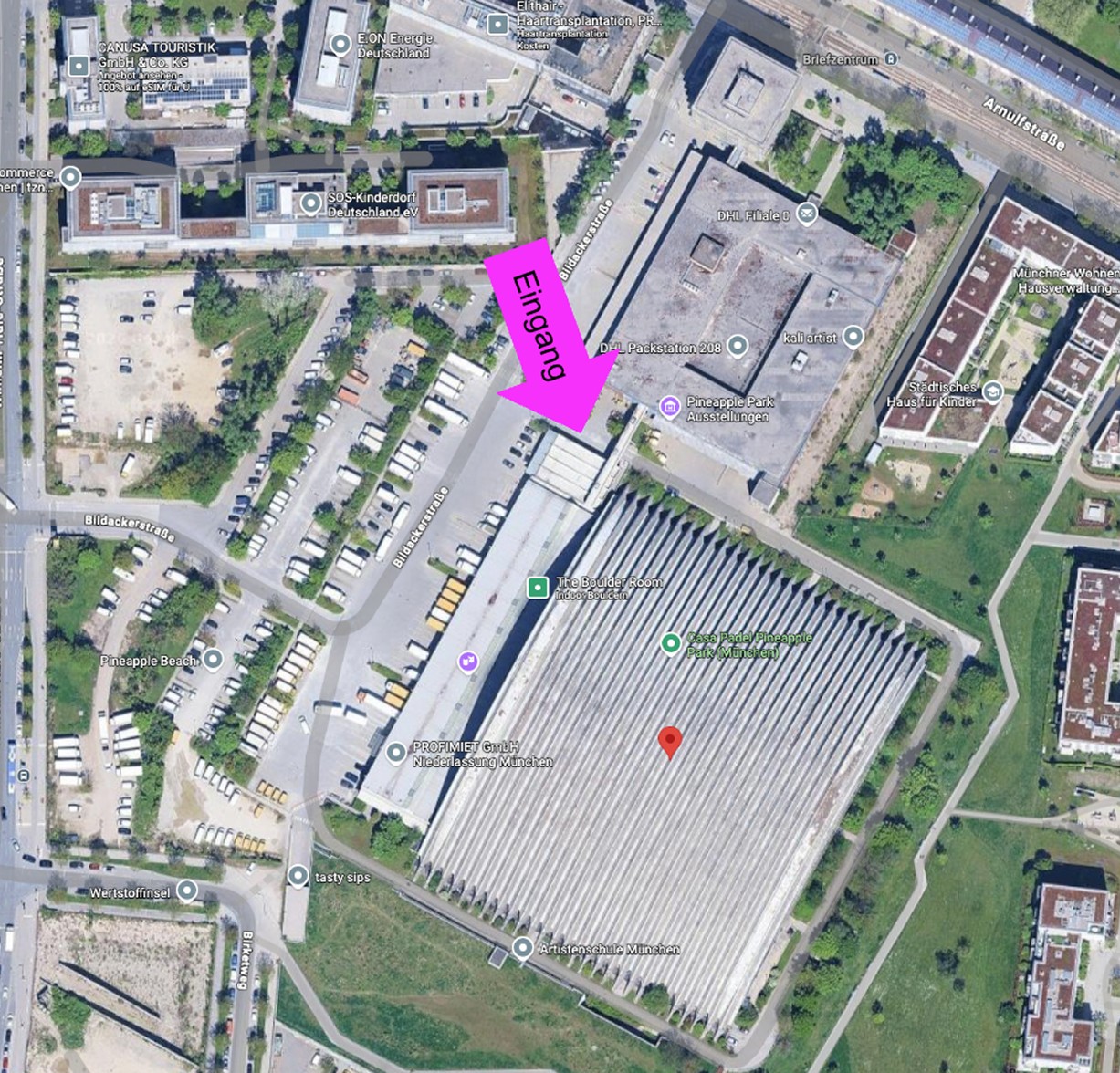 Außenansicht des Pineapple Park in München, dem Standort von The Boulder Room – grüne Fassade unter blauem Himmel.