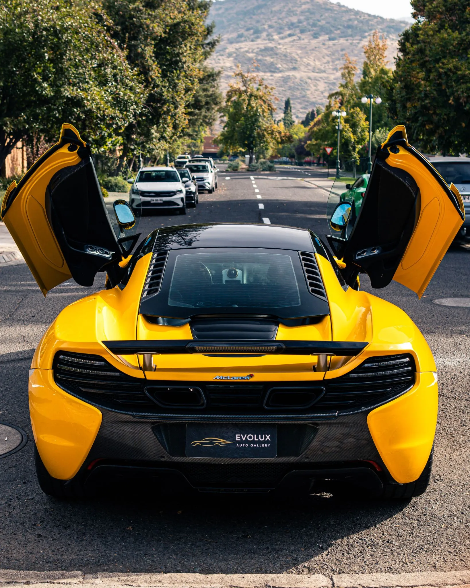McLaren MP4-12C gris visto desde atrás con escapes centrales y luces traseras estrechas