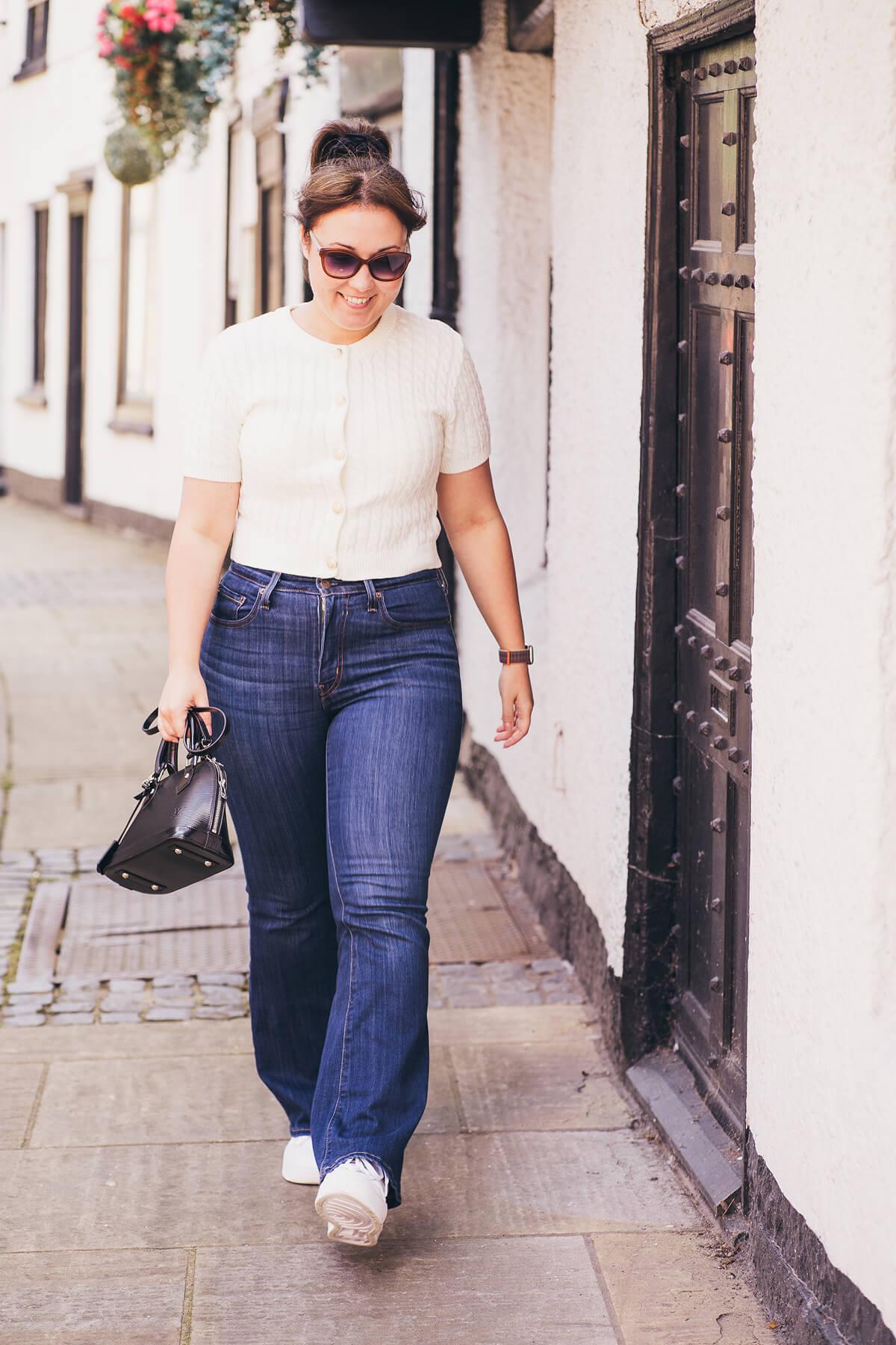 Aniko Rucz walking along a UK street, sharing her journey as a short-term rental host and property professional