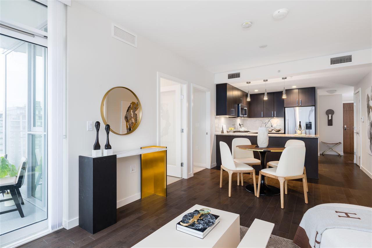 Modern living space featuring a dining area, sleek kitchen, and bright decor with wood accents.