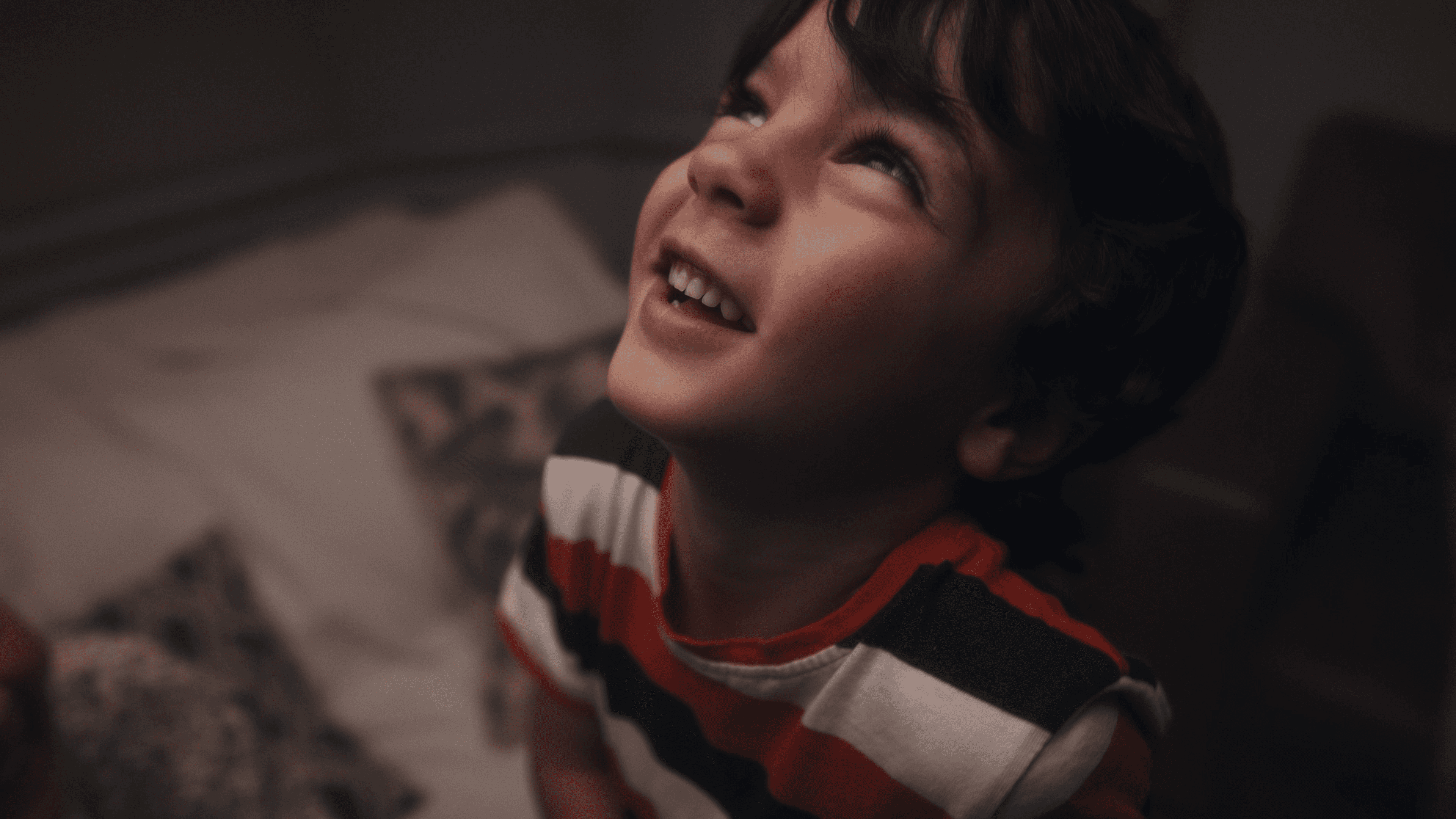 A happy young boy grinning upwards