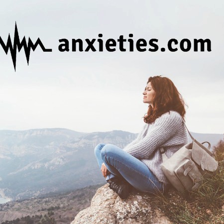 a woman sitting crossed legged on a rock, with anxieties.com written overtop