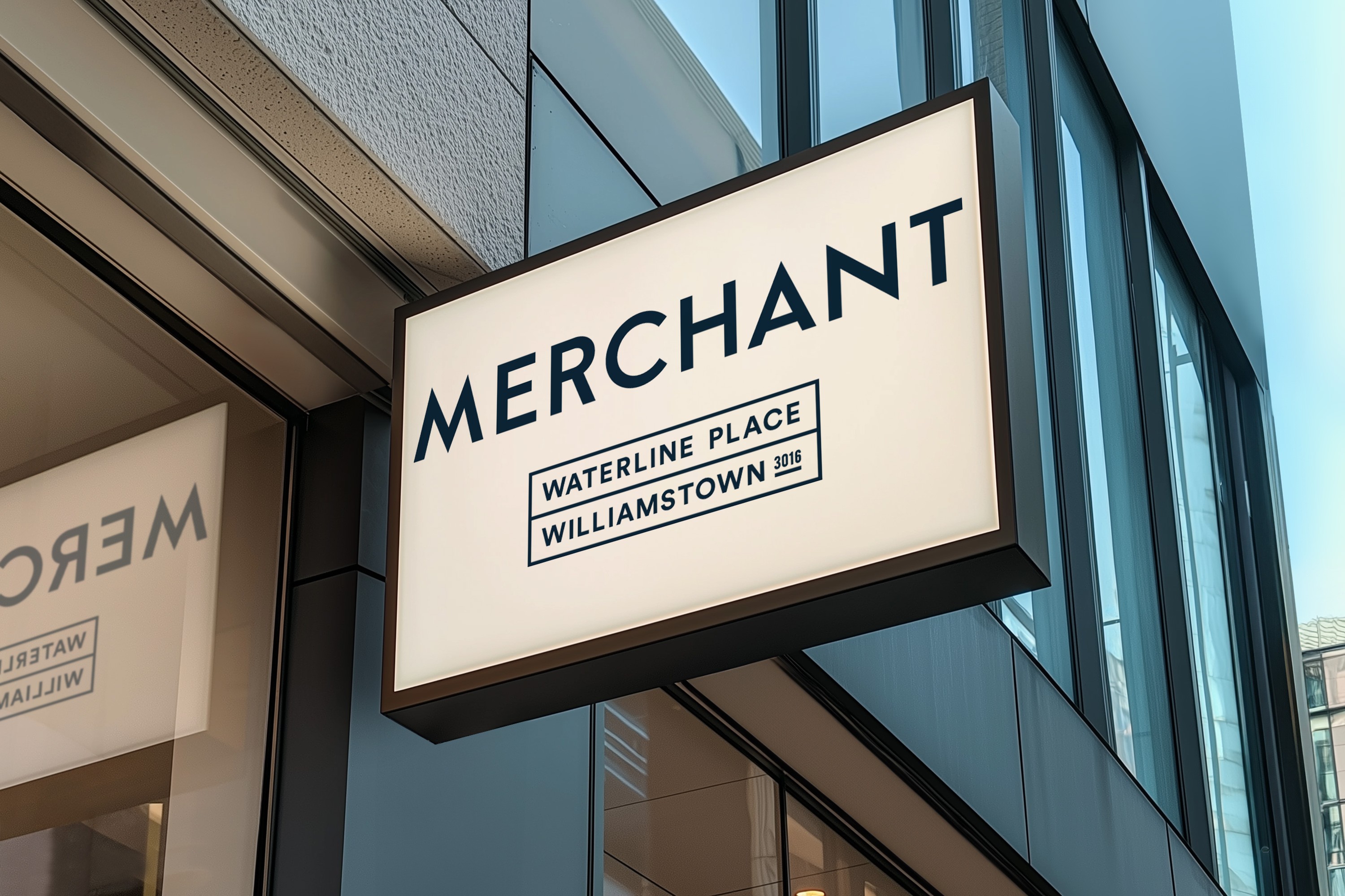 Illuminated sign reading "MERCHANT" in bold letters, with "Waterline Place Williamstown 3016" below. Modern building facade in the background.