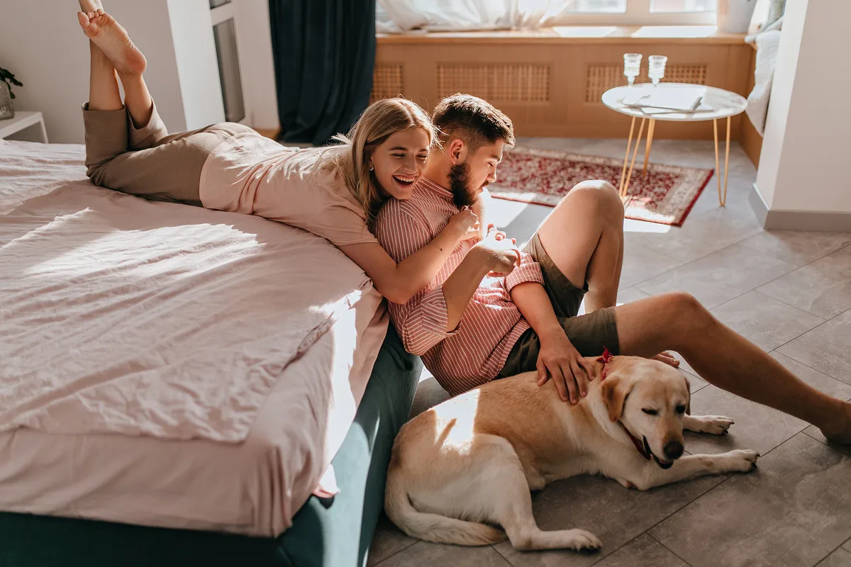 happy couple with dog living in an apartment that works for their lifestyle needs