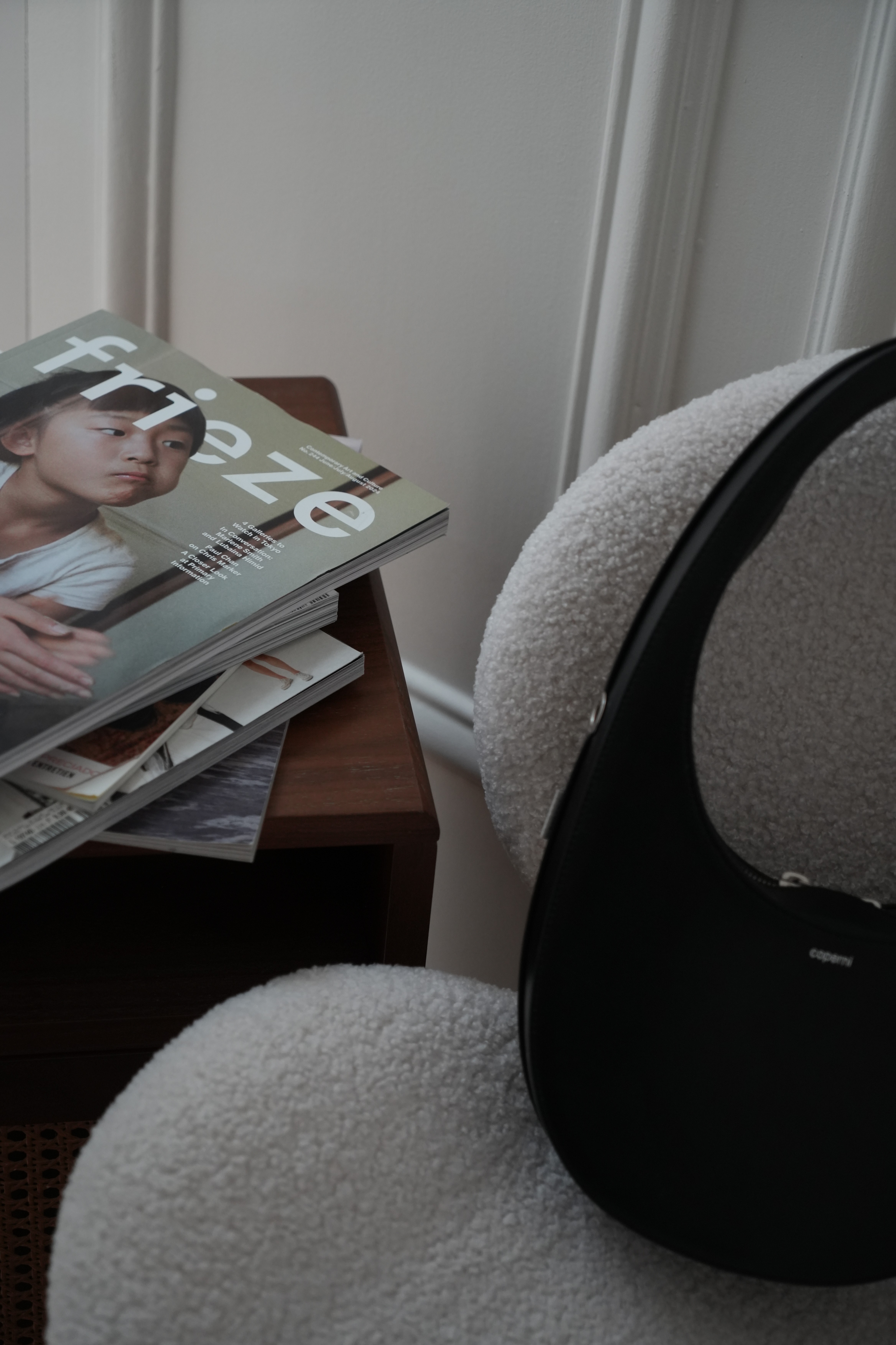 Two people are collaborating at a table with laptops, surrounded by colorful swatches and notes. The atmosphere is creative and focused.