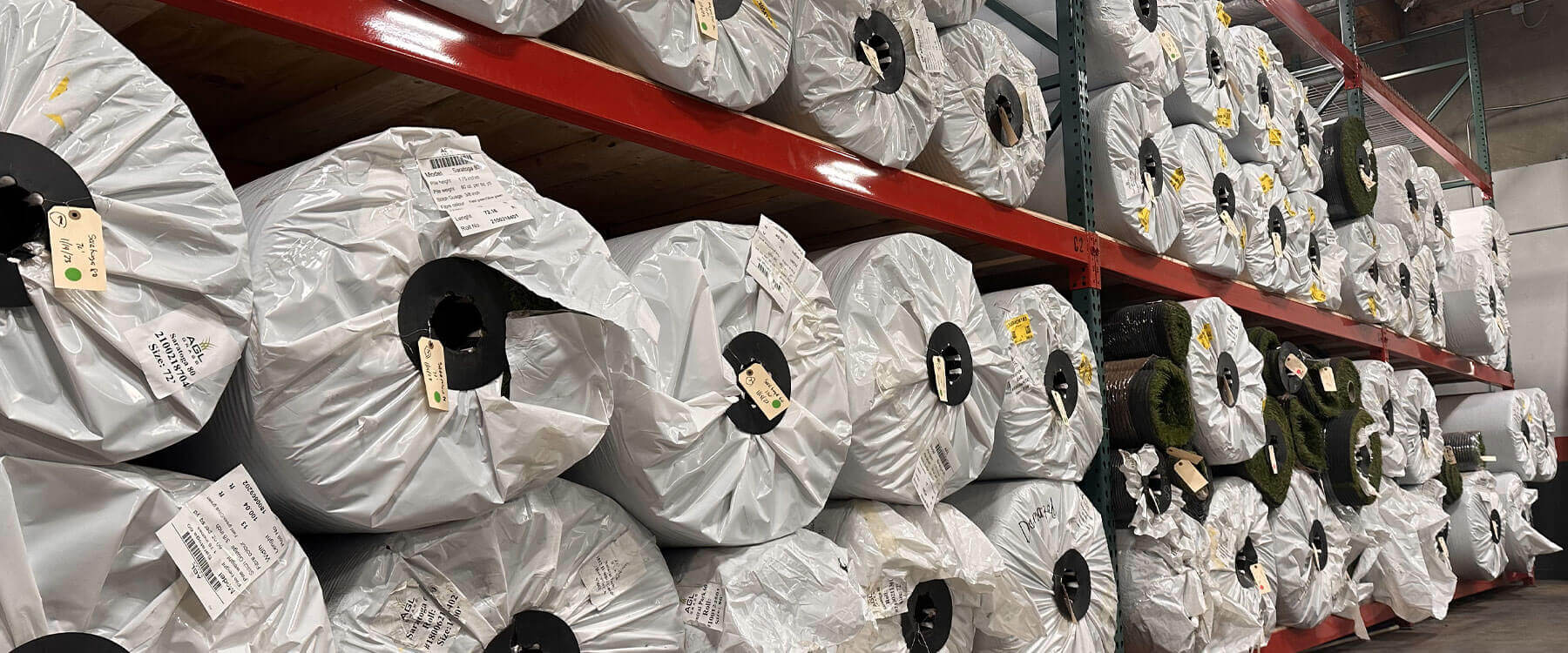 This is a photograph of AGL Grass North's fully stocked warehouse, which offers high-quality artificial grass with fast availability, ensuring a reliable supply for residential, commercial, and sports installations.