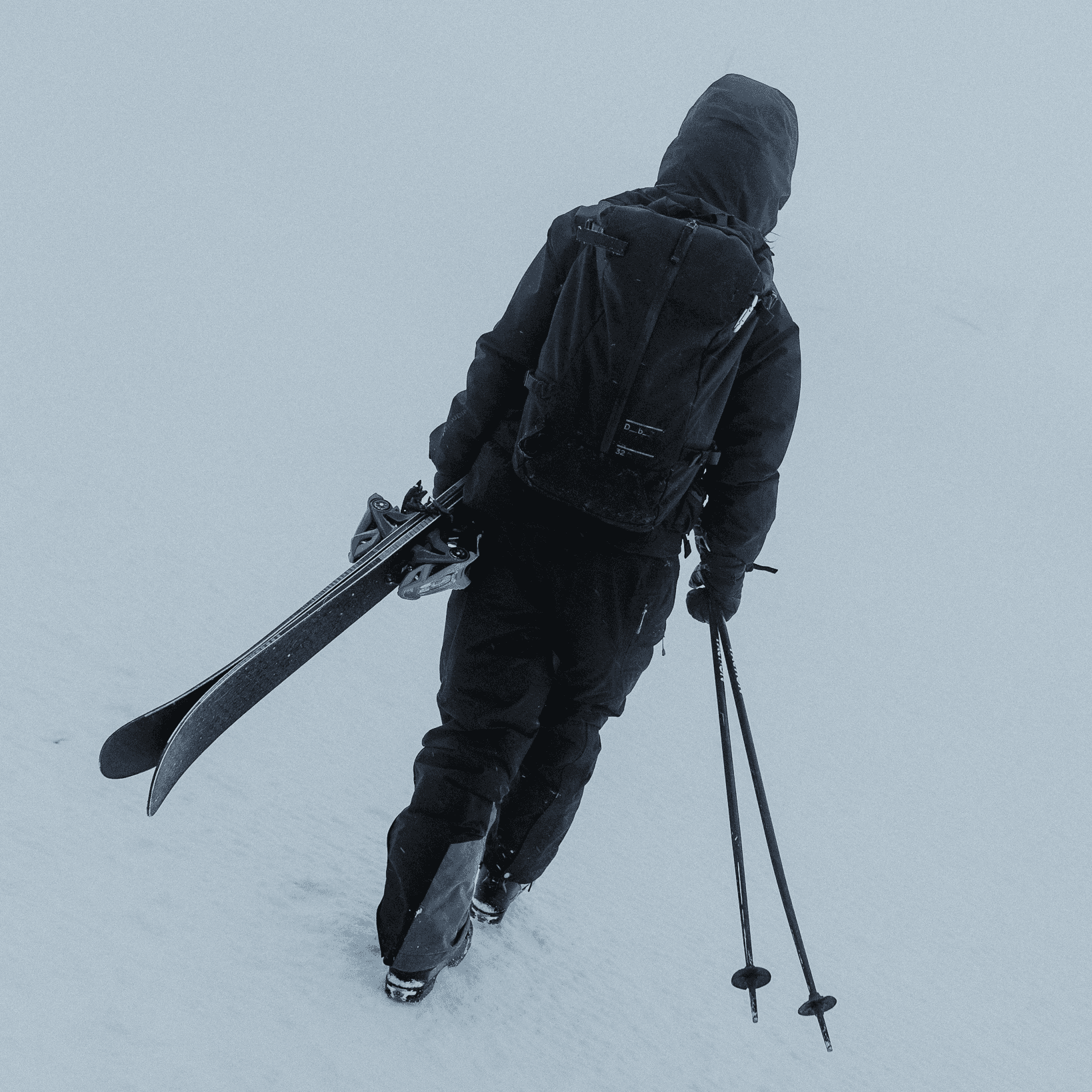 skier walking in black outfit.