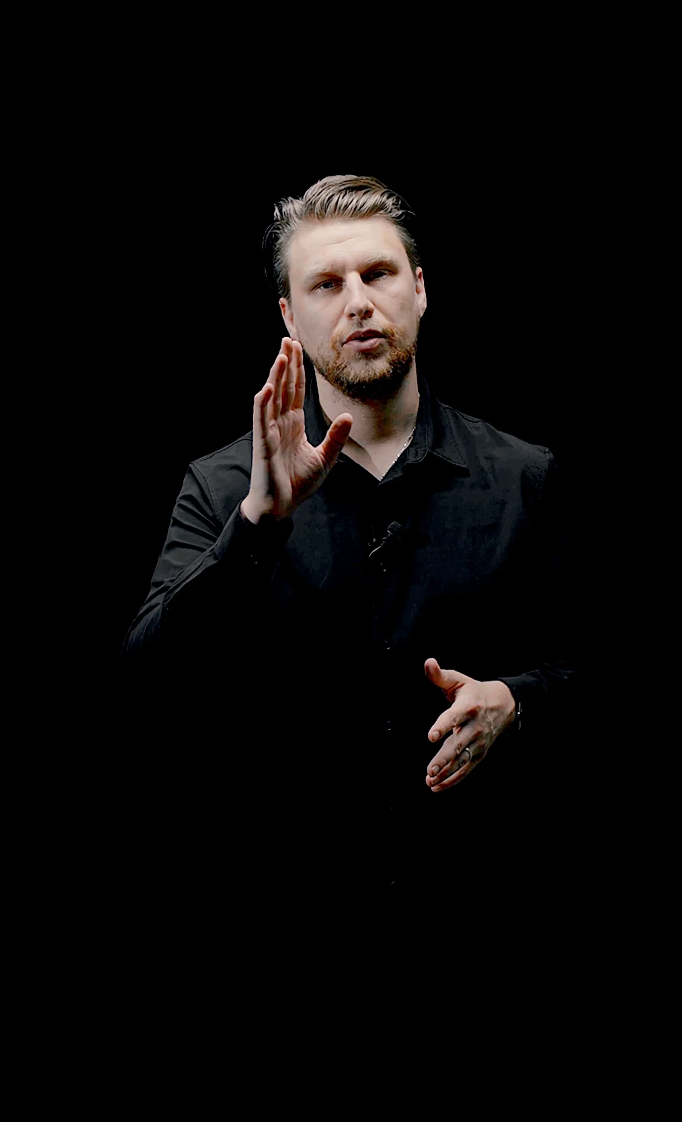 Kirill Samarits, marketing executive and entrepreneur, explaining a point against a black studio background