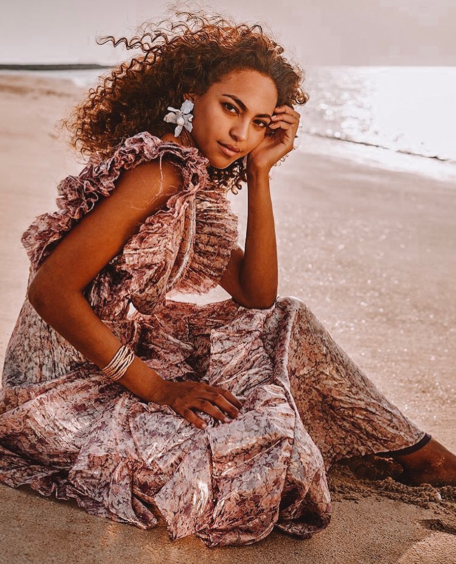 Black-and-white party photo of a smiling man in a check blazer among a crowd.