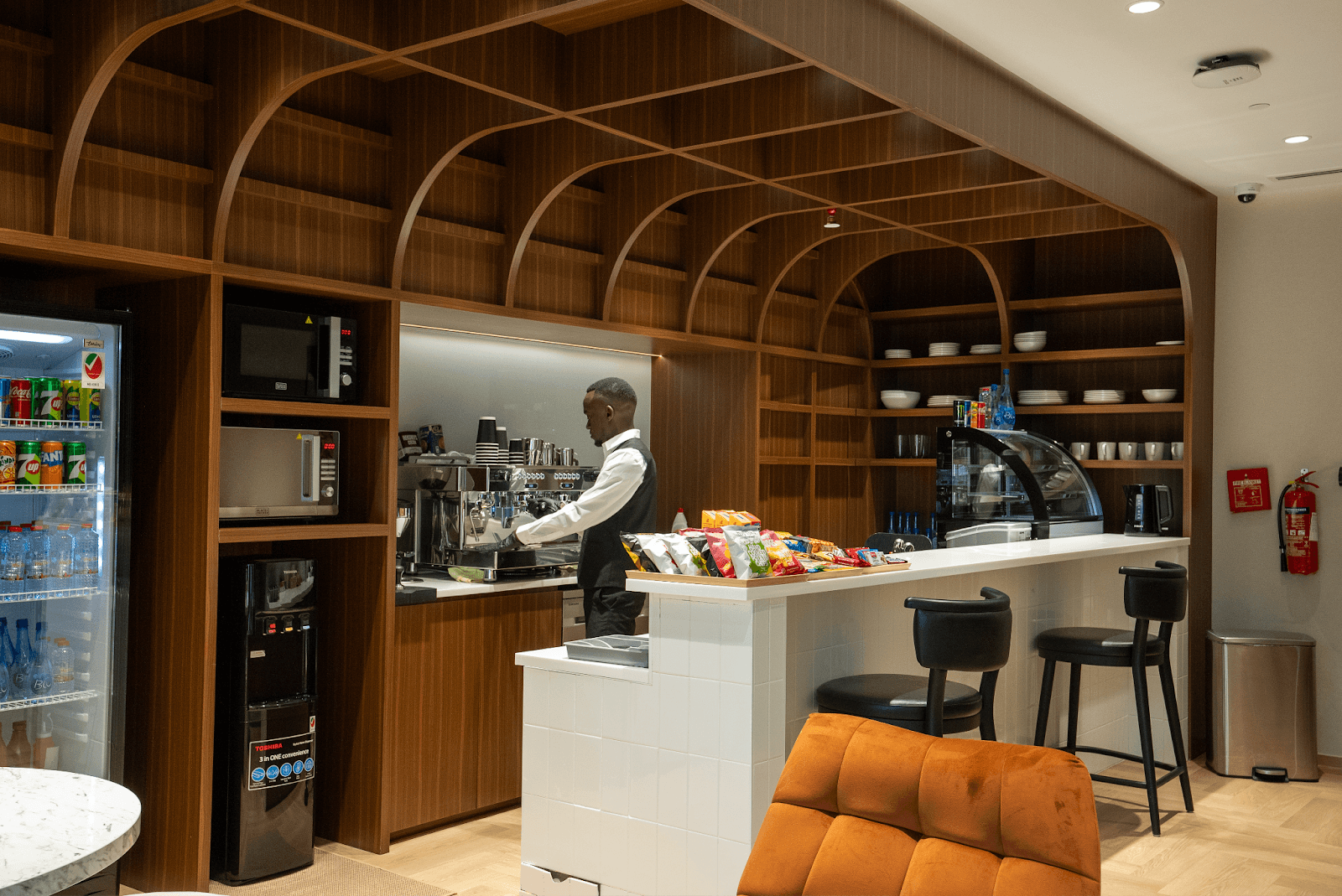 Barista preparing coffee behind a modern cafe counter inside a Office Square’s lounge in Abu Dhabi
