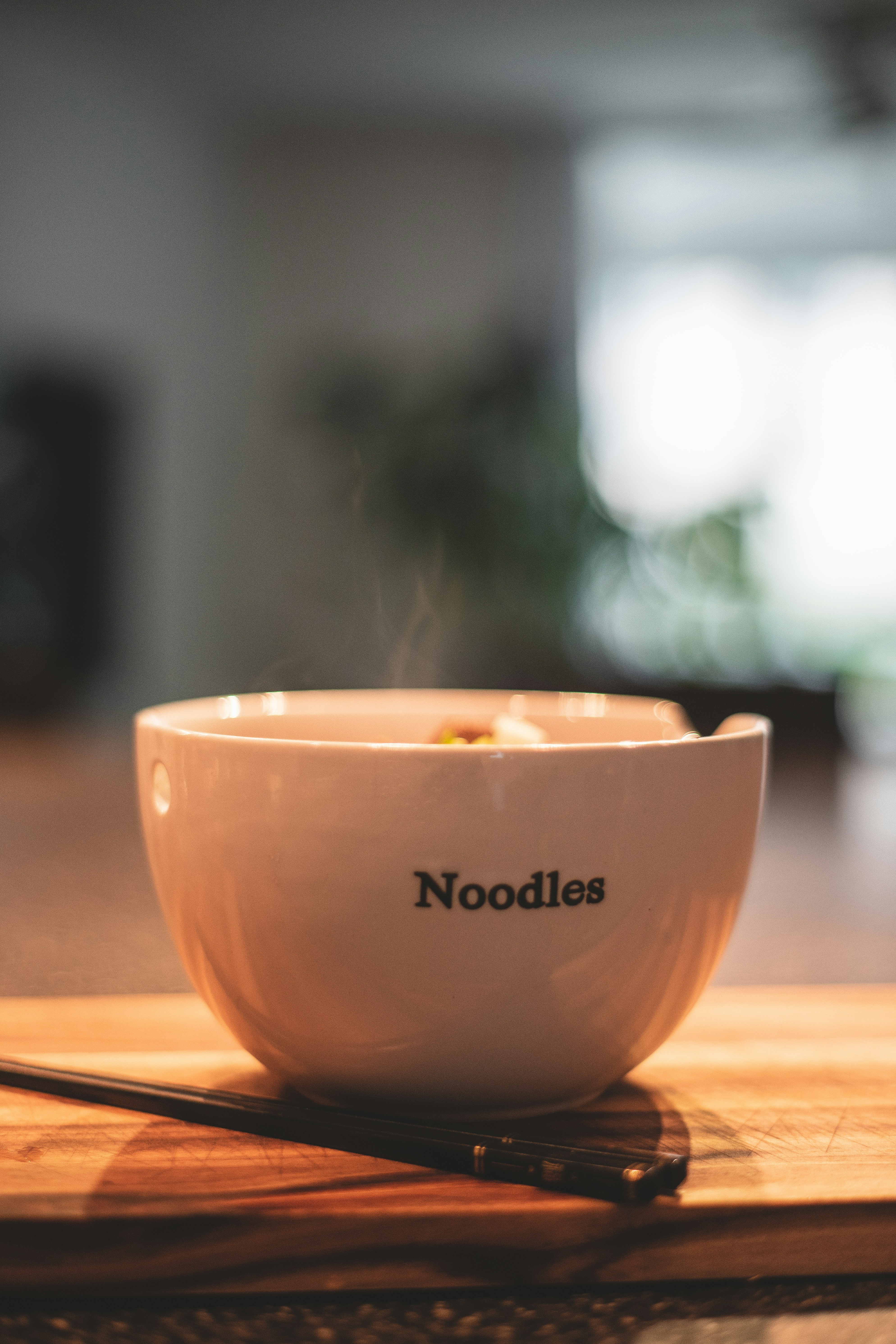 a bowl of noodles on a wooden table