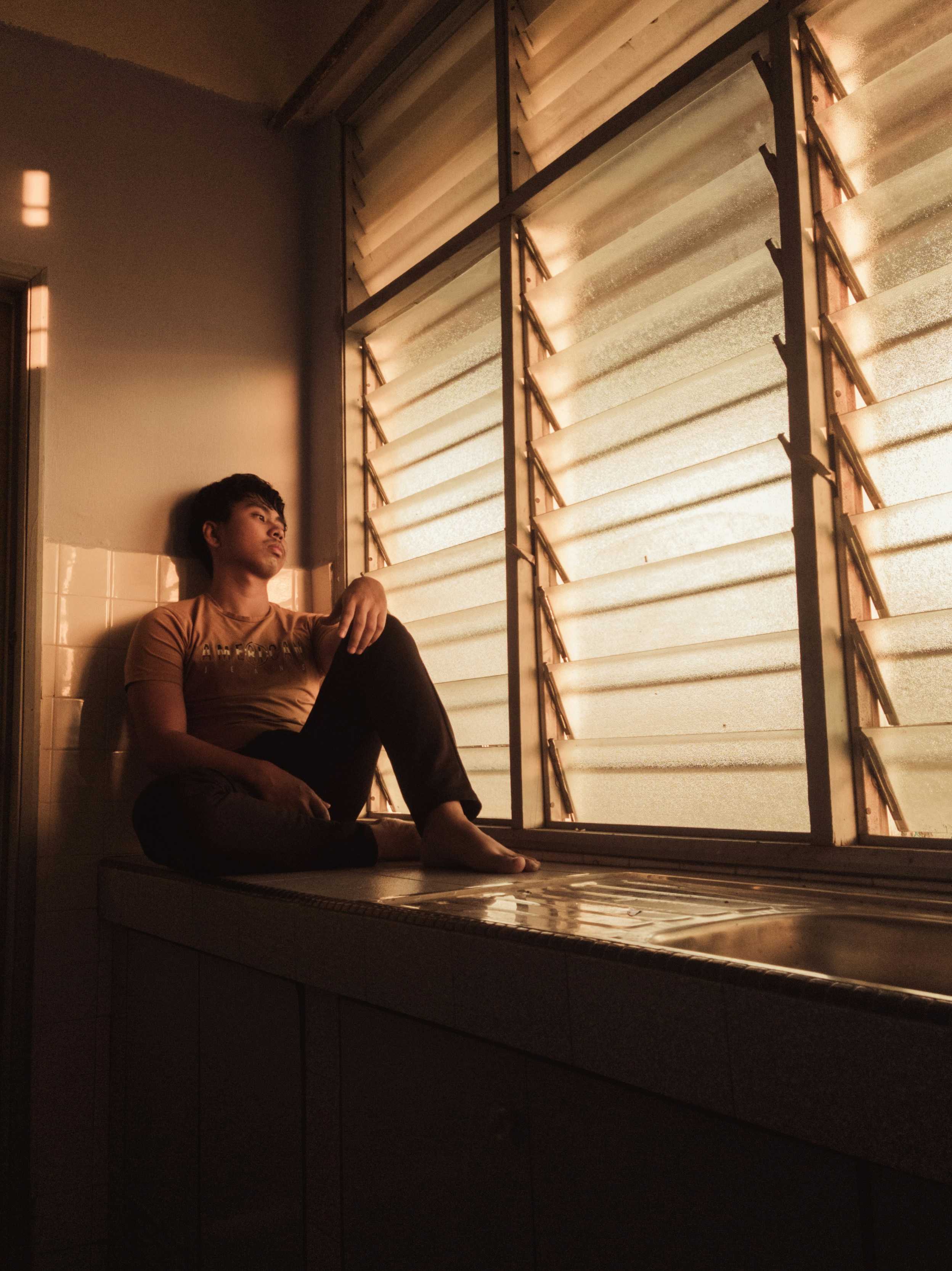 a woman sitting on a counter in front of a window