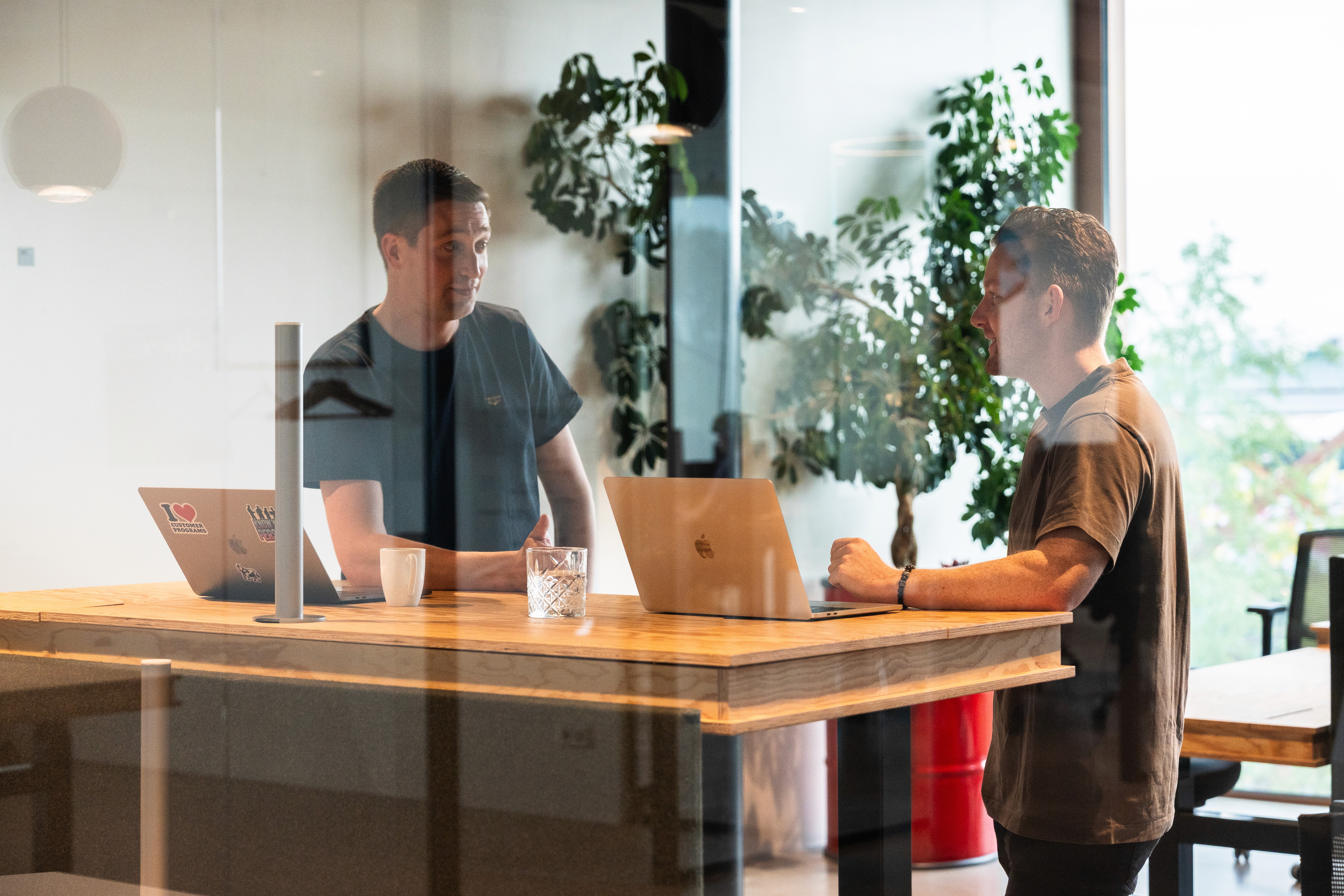 A cell phone sitting on top of a wooden table next to a keyboard
