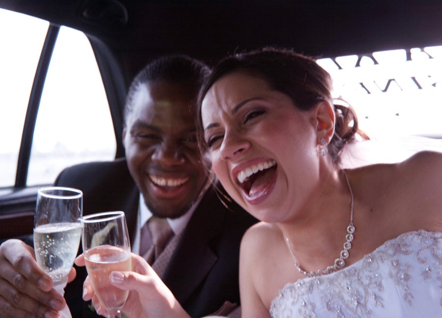 Bride and groom laughing together as they arrive at the wedding reception.