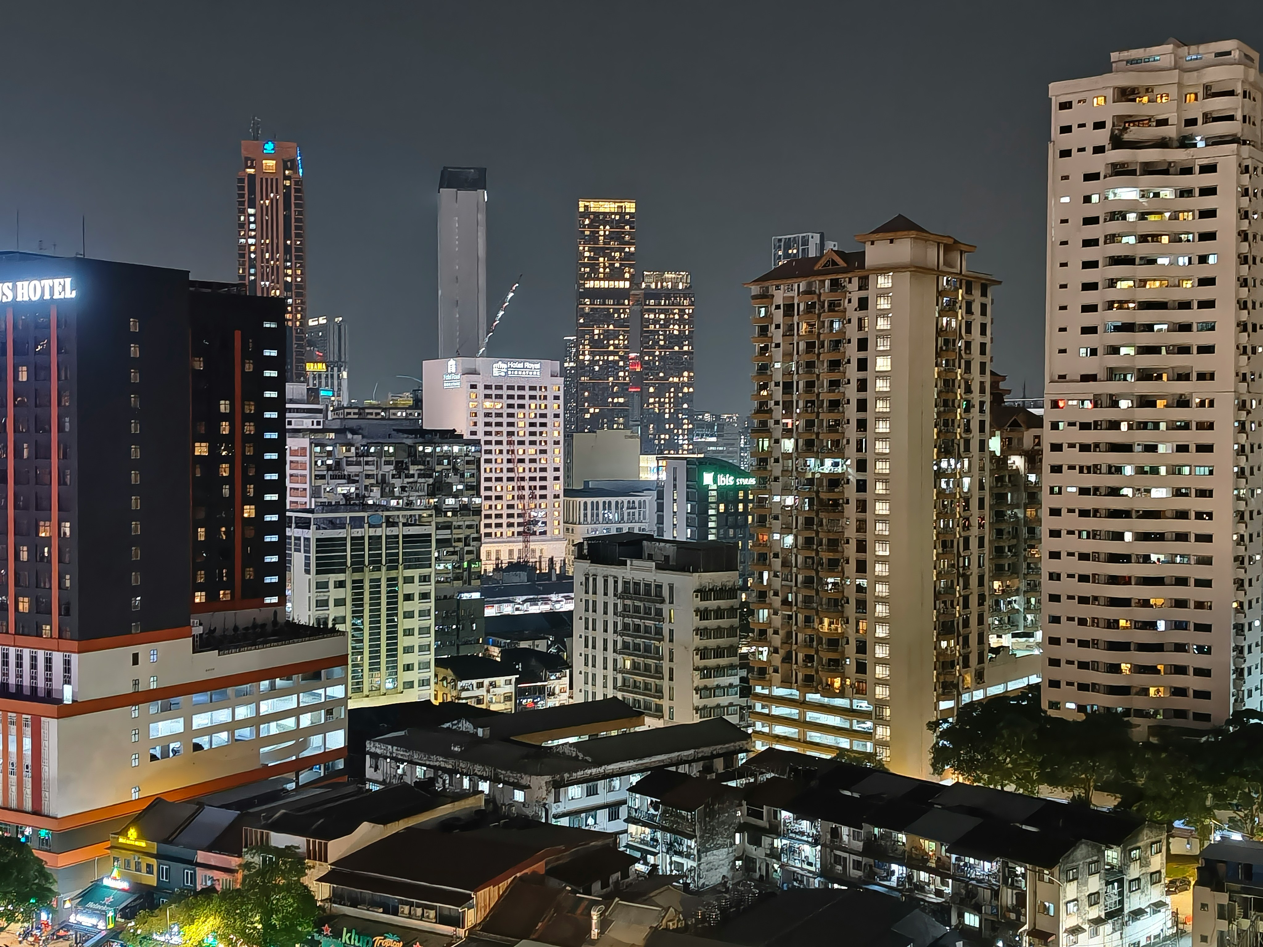 Illuminated city skyline with tall buildings at night.