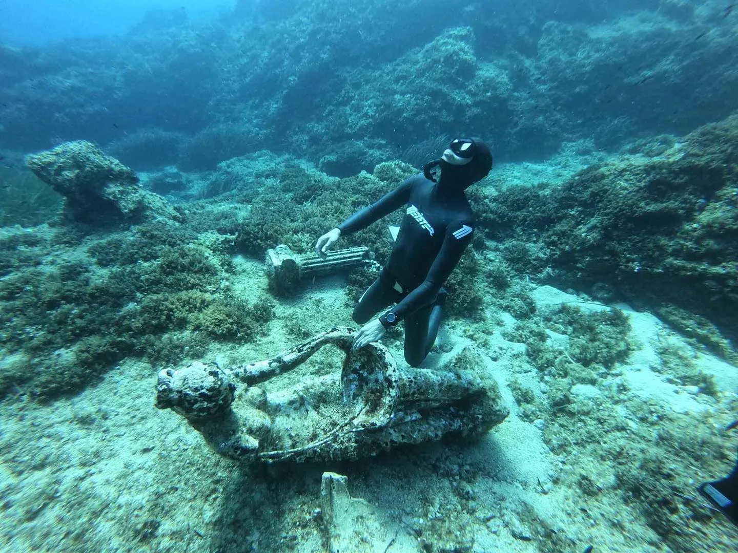 freediver meister sitting on a rock underwater