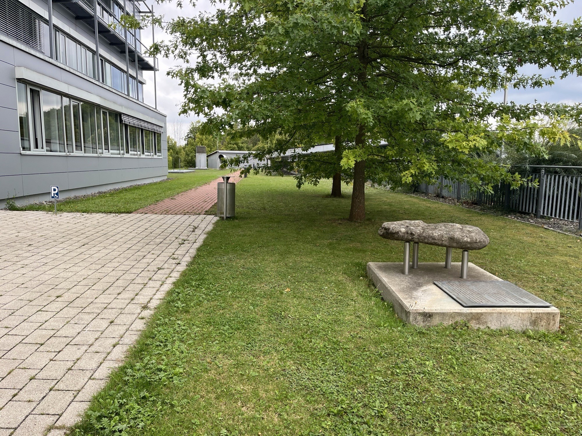 Garten mit Bäumen und Steinskulptur