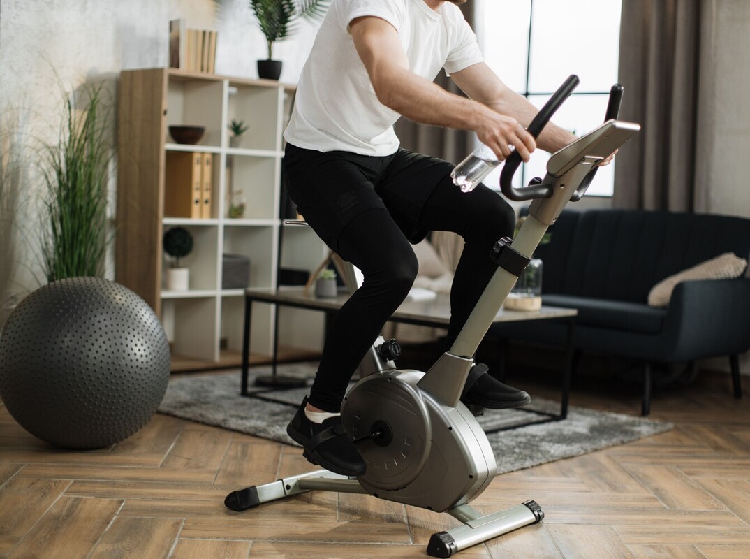 man using an exercise bike to lose weight at home in his living room