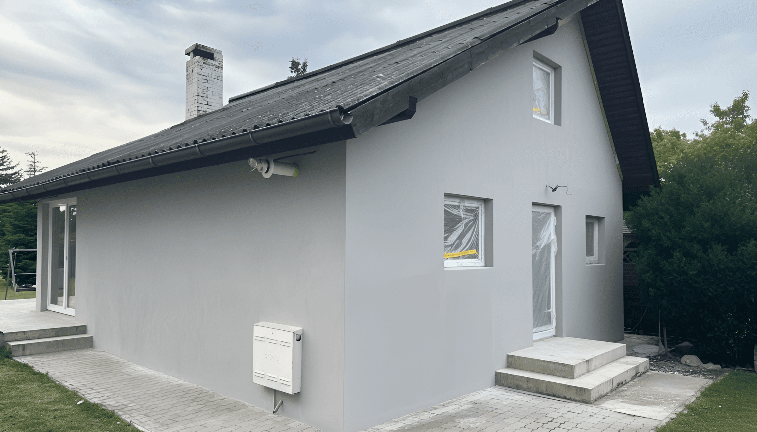Frisch renovierte Hausfassade in Grau nach umfassender Sanierung eines Einfamilienhauses in Wien.