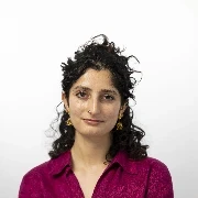 Headshot of smiling woman in burgundy shirt with fabulous long curly brown hair