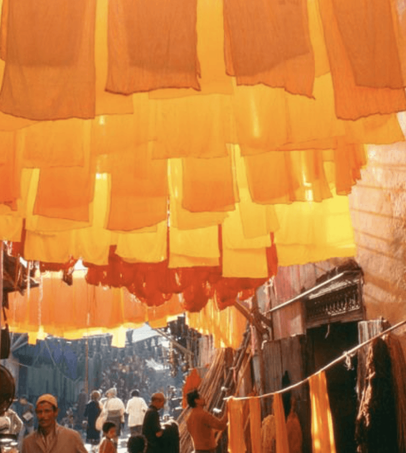 a group of women standing on top of a sandy beach