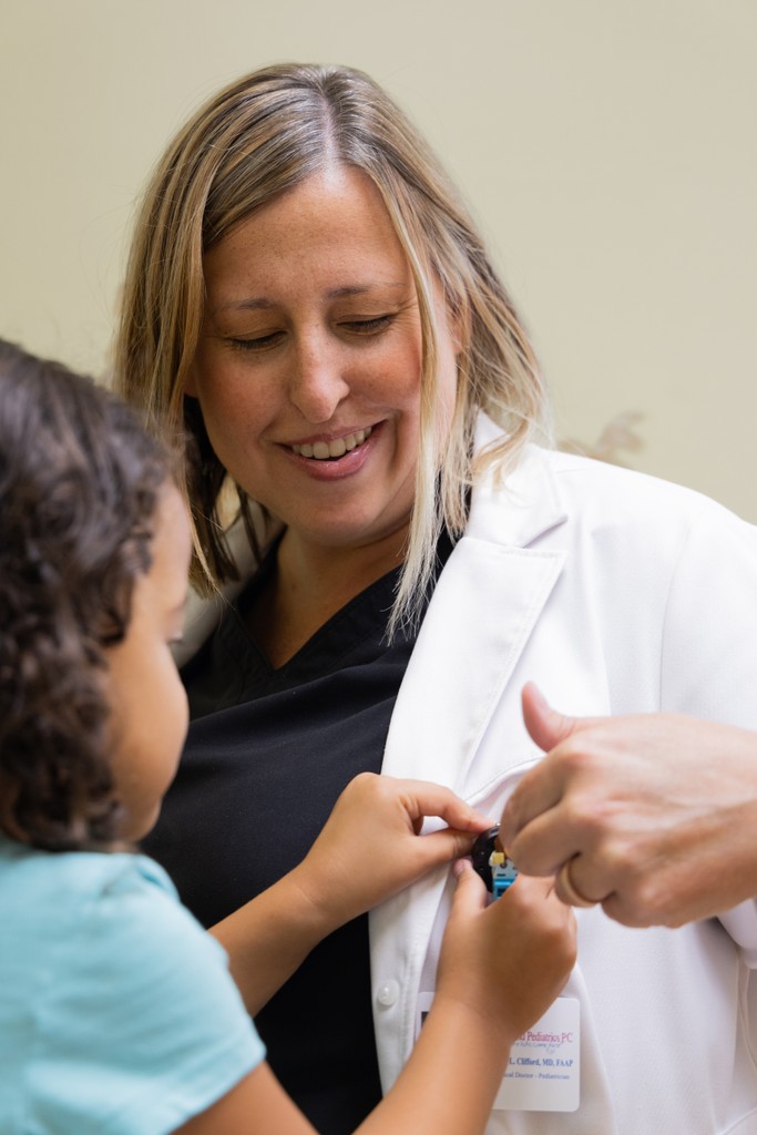 Young patient playing with Pediatrician's coat.