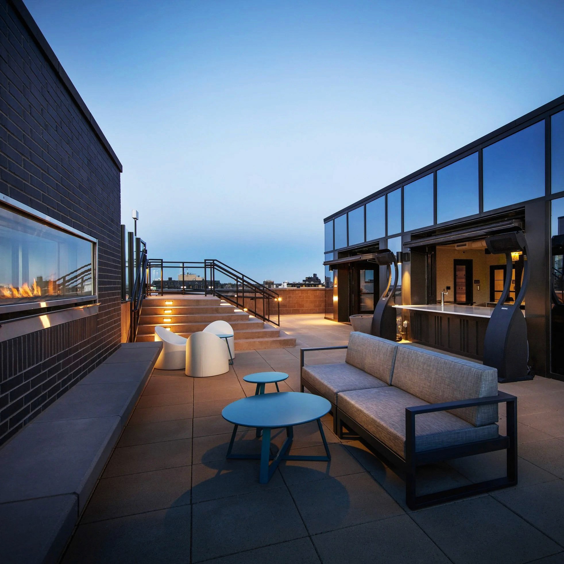 Rooftop patio with seating and a modern bar.