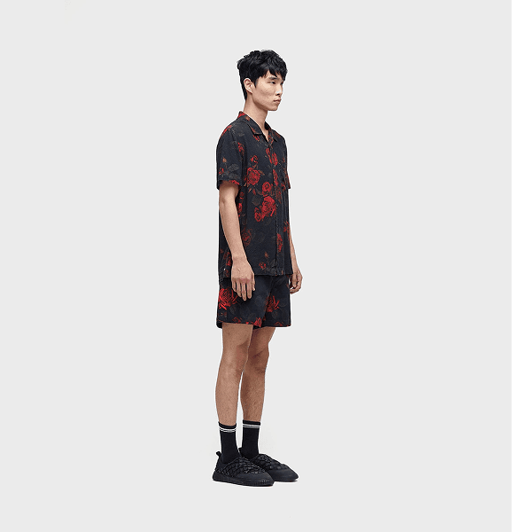 suggest me a good seo based alt text ChatGPT said: "Male model wearing a black and red floral print co-ord set with matching shirt and shorts, paired with black woven sneakers and striped socks. Streetwear fashion style showcasing bold floral patterns and modern aesthetics."