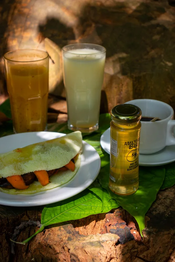 Garrafa de mel em composição de café da manhã, com tapioca e café.