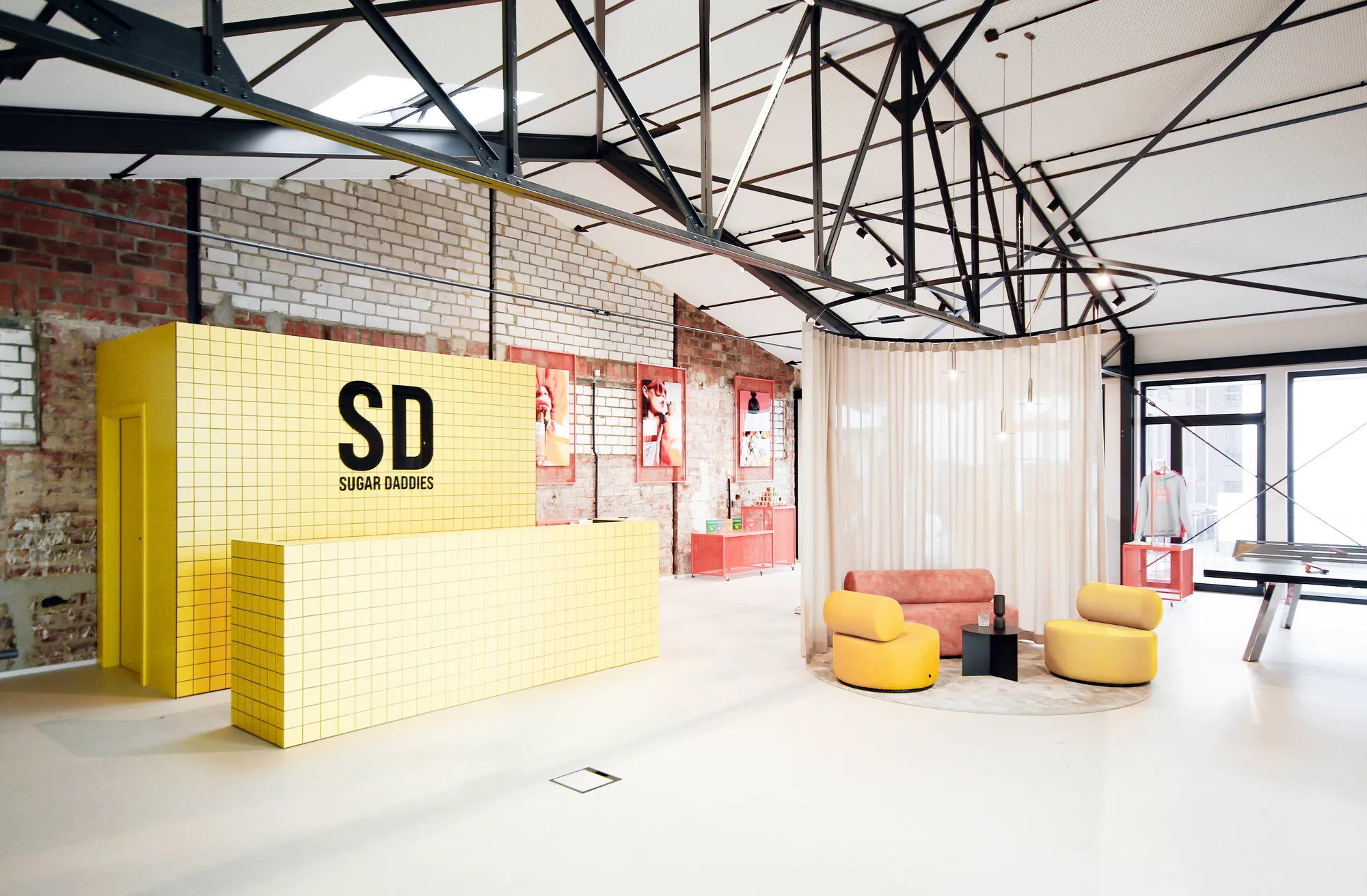Yellow tiled SD Sugar Daddies counter with lounge chairs and sheer curtain in the loft.