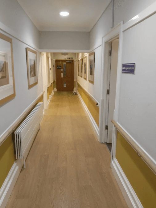 A narrow hallway with bright lights and doors leading out